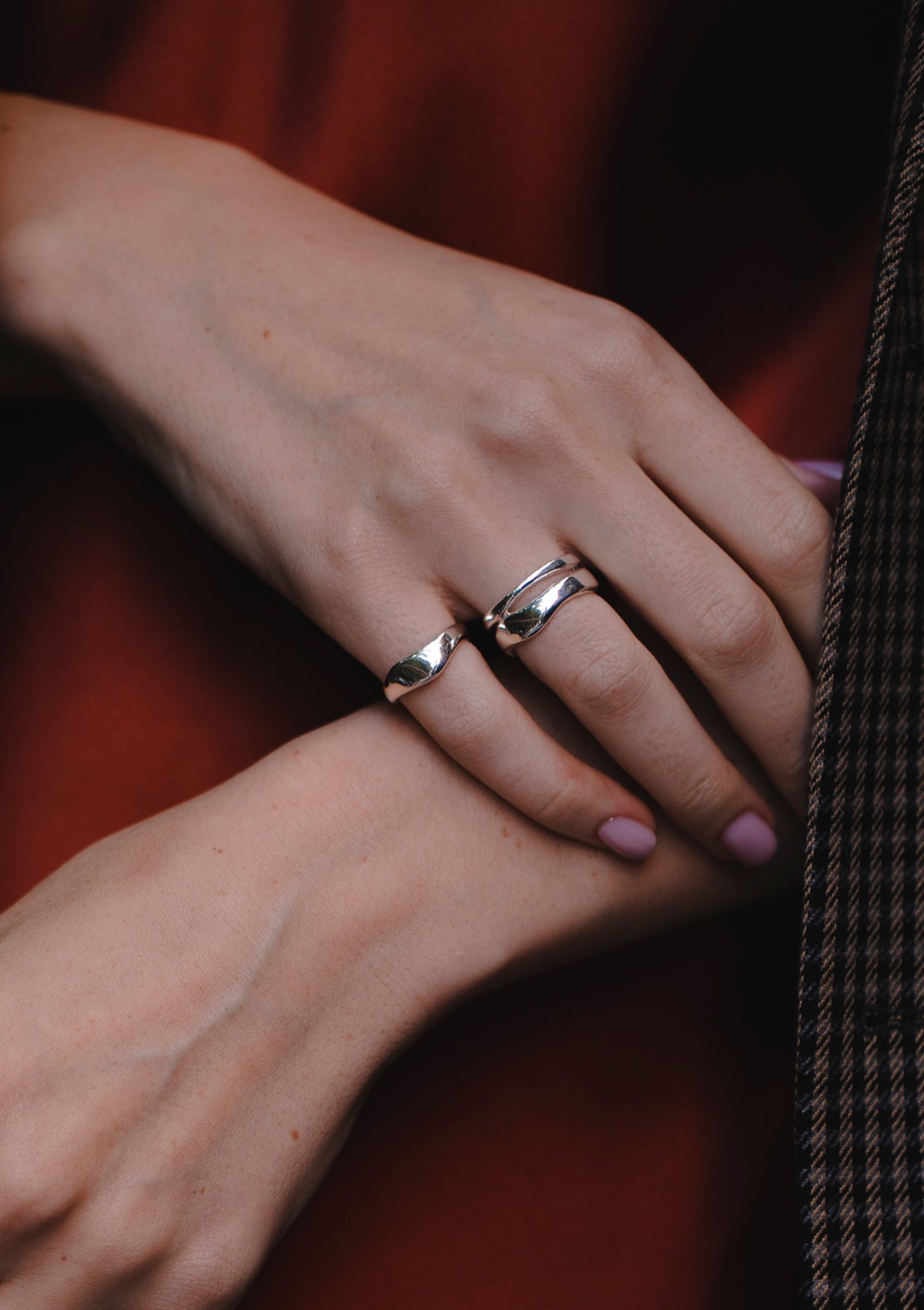 Wavy silver ring with polished mirror finish, flat modern band worn casually
