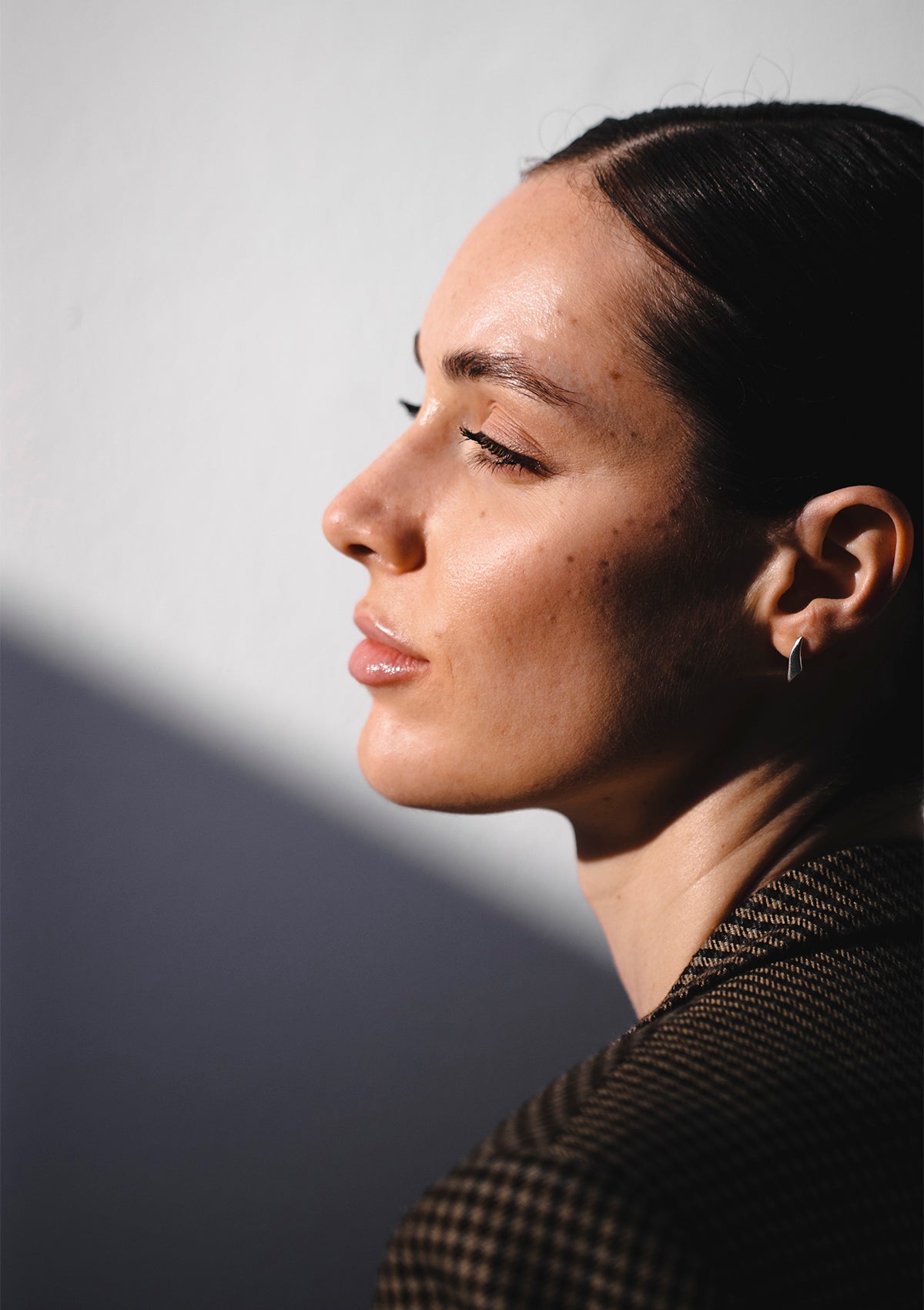 Tiny silver sculptural earrings in artistic close-up, elegant modern style