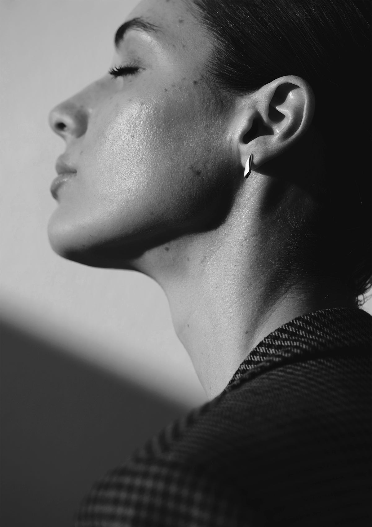 Bold shot of sterling silver earrings with unique shape, designer jewelry in monochrome