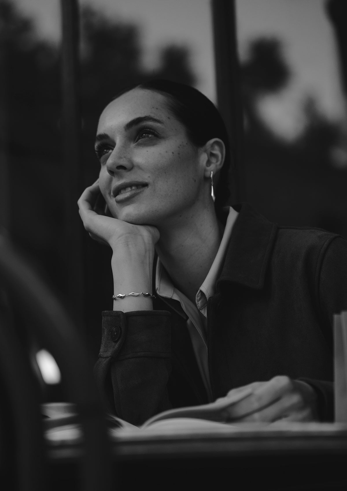 Monochrome image of polished sterling silver bracelet, minimalist water-inspired design on wrist