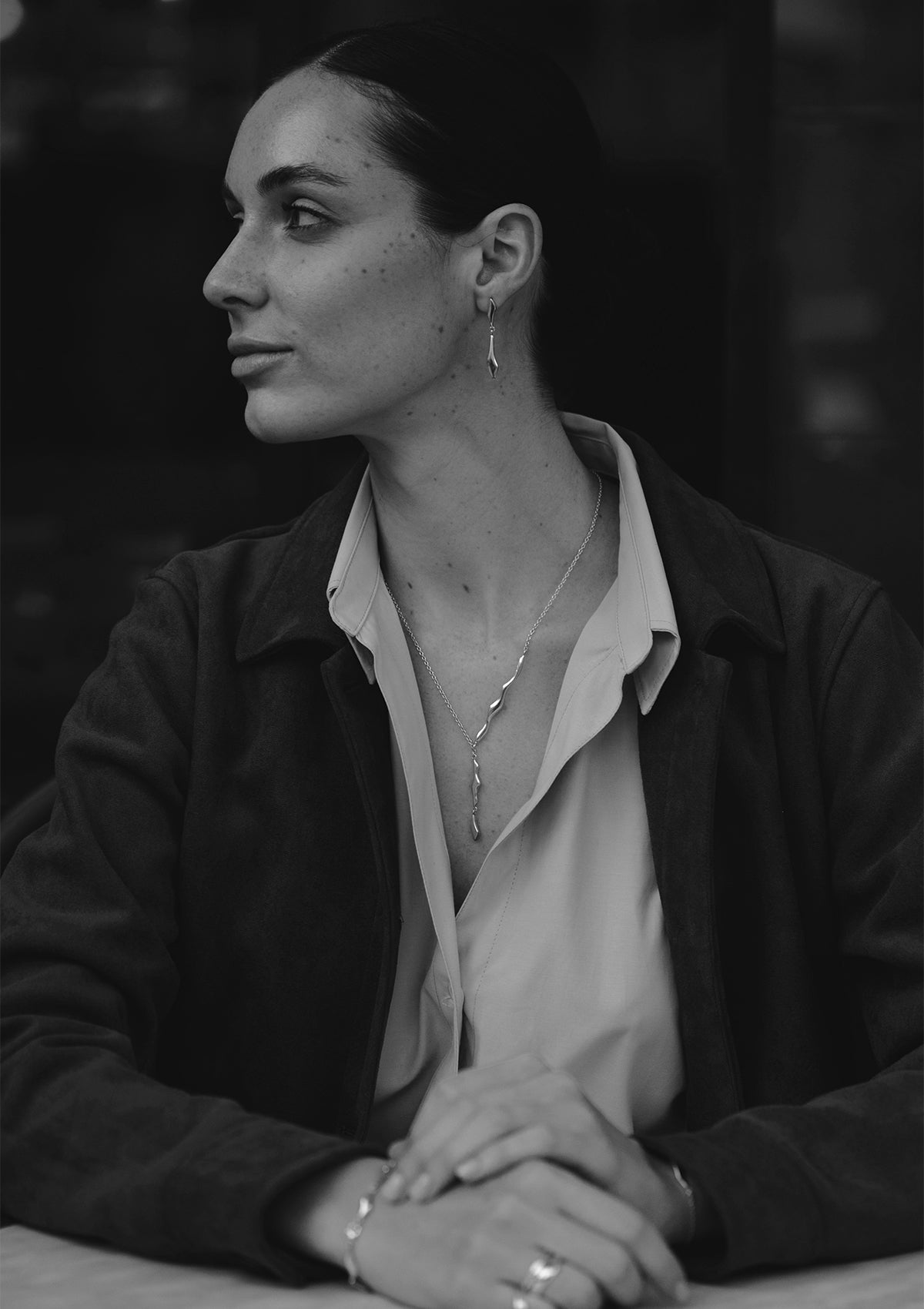 Artistic shot of adjustable silver lariat necklace with curved elements, modern statement jewelry