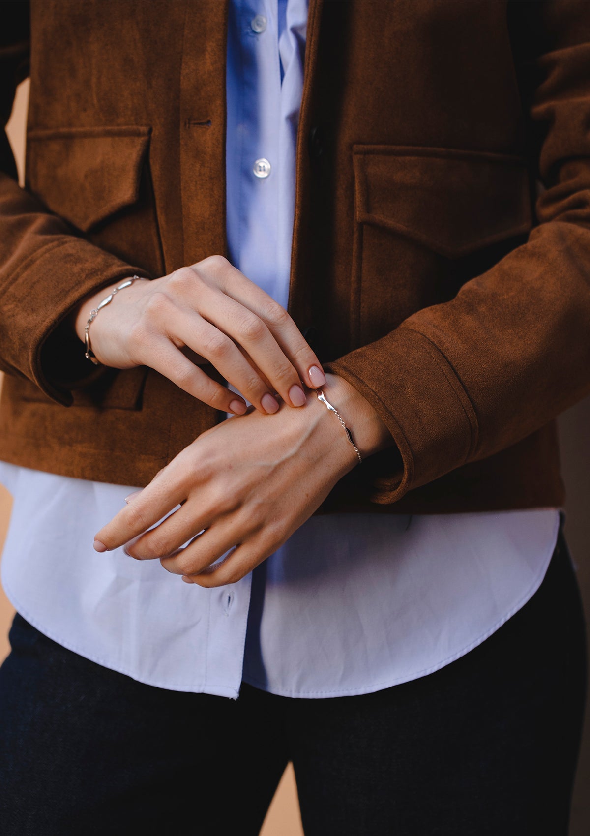 Unique silver bracelet with polished wavy elements, elegant and casual styling with brown jacket