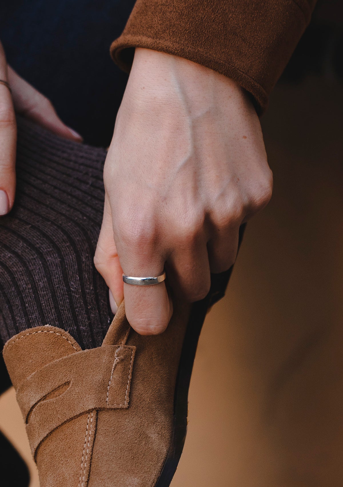 Minimal silver ring worn on hand, sleek and tapered for an elegant, timeless look