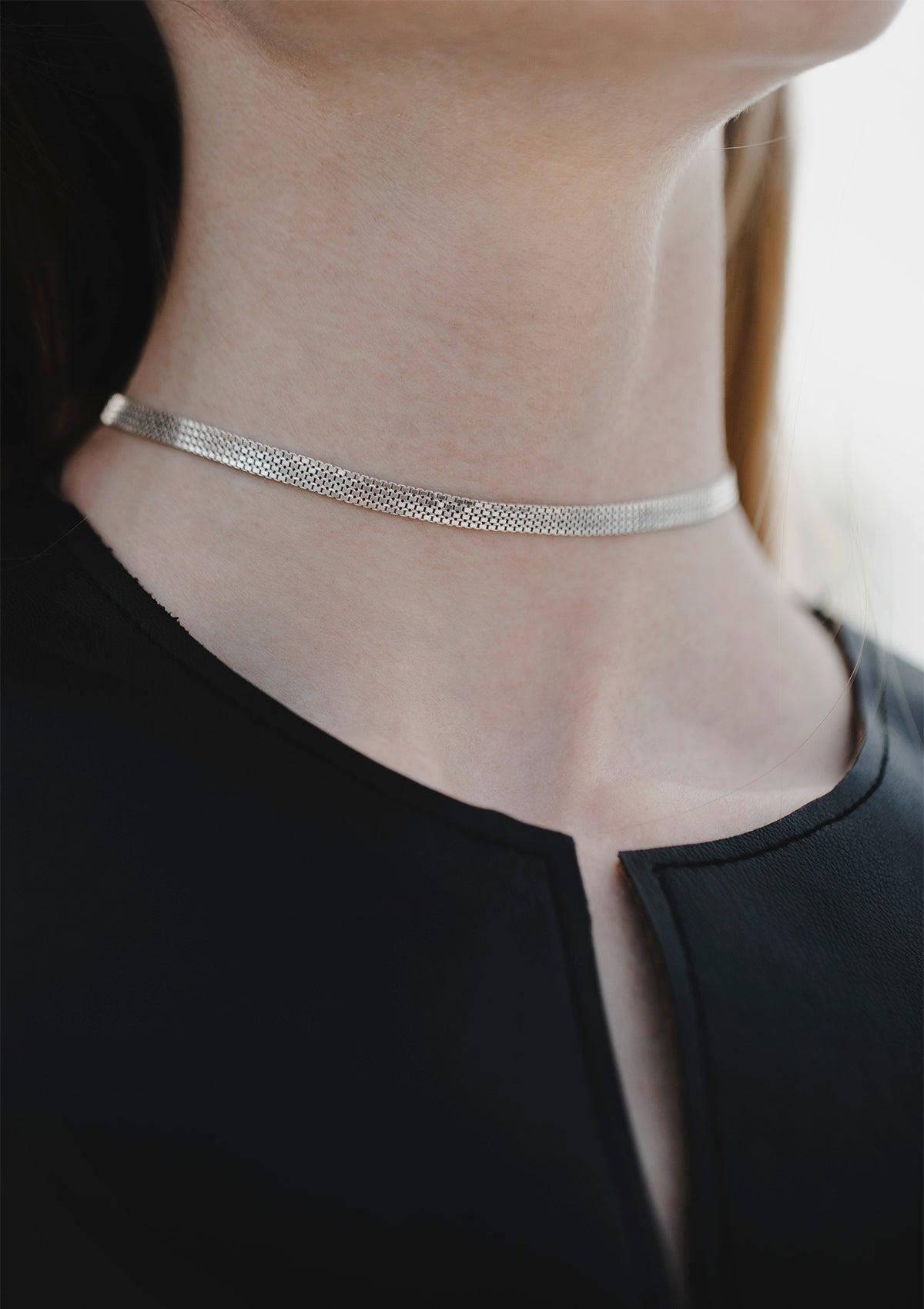 Simple silver choker styled with modern black neckline, sleek geometric contrast for everyday elegance