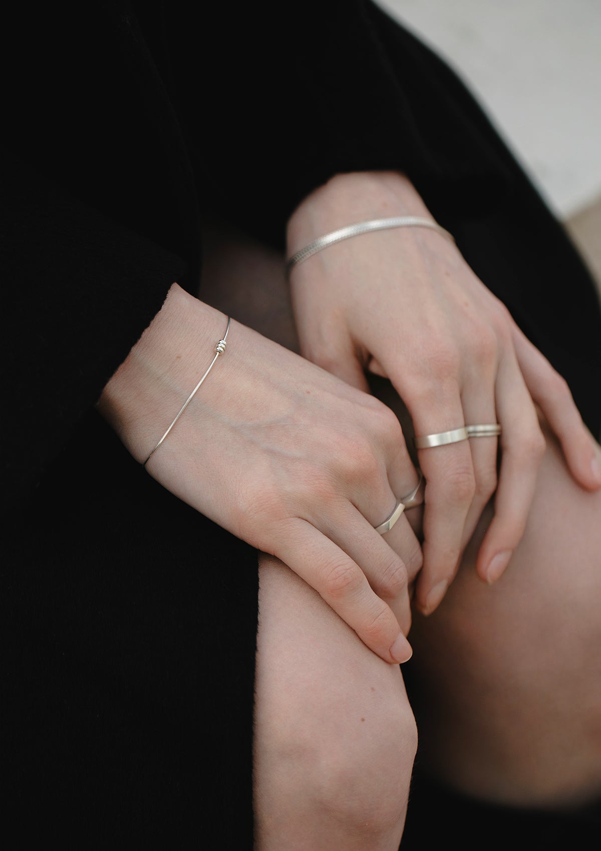 Minimalist silver bracelet with trio bead detail, worn on wrist, model’s hands resting naturally