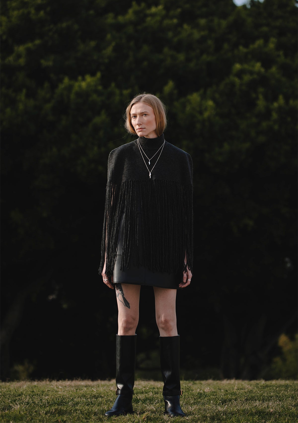 Signature silver necklace with curved pendant, artisanal jewelry styled with modern outfit
