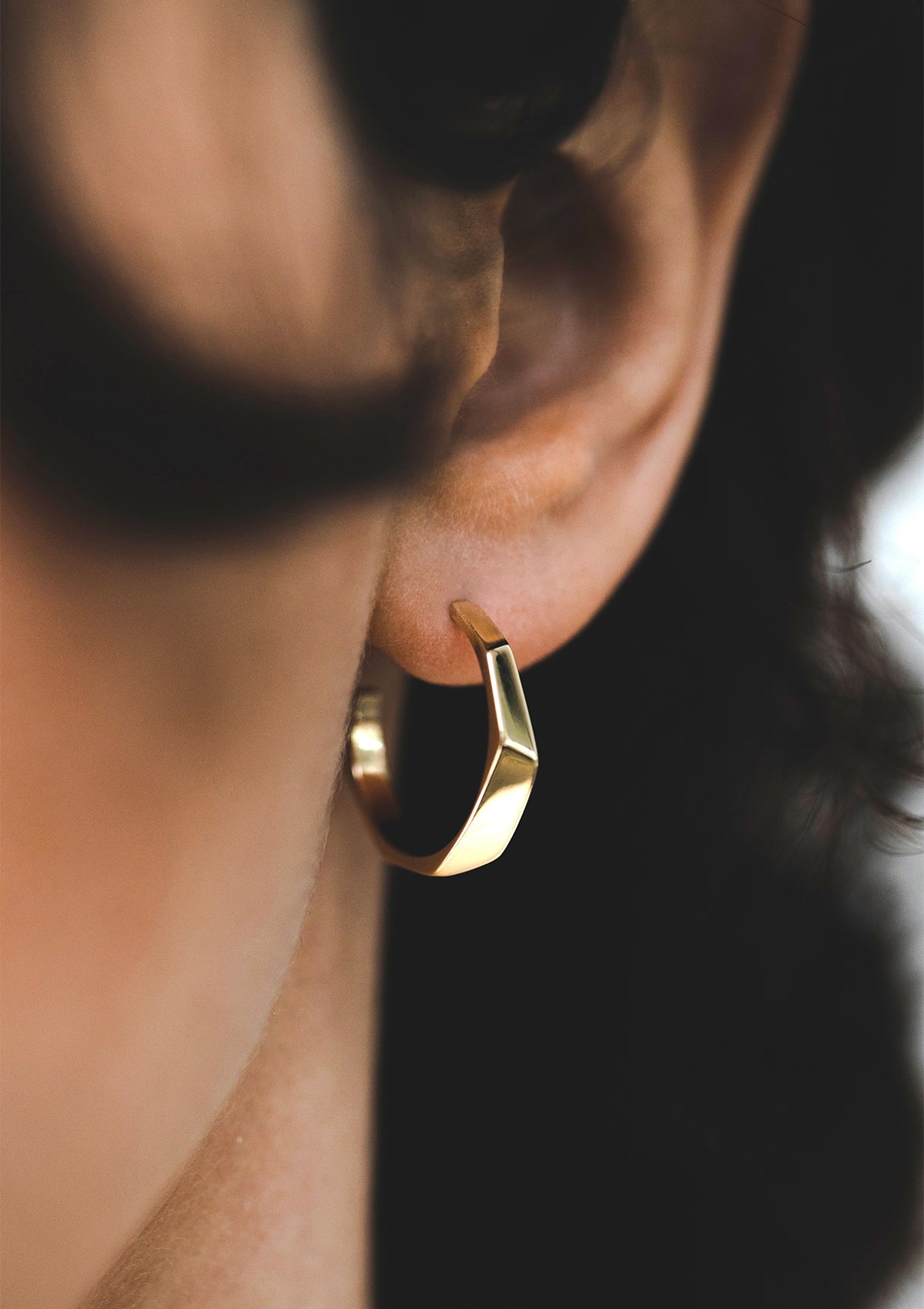 14K gold hoop earrings with sculptural faceted design, worn close to ear for elegant everyday style