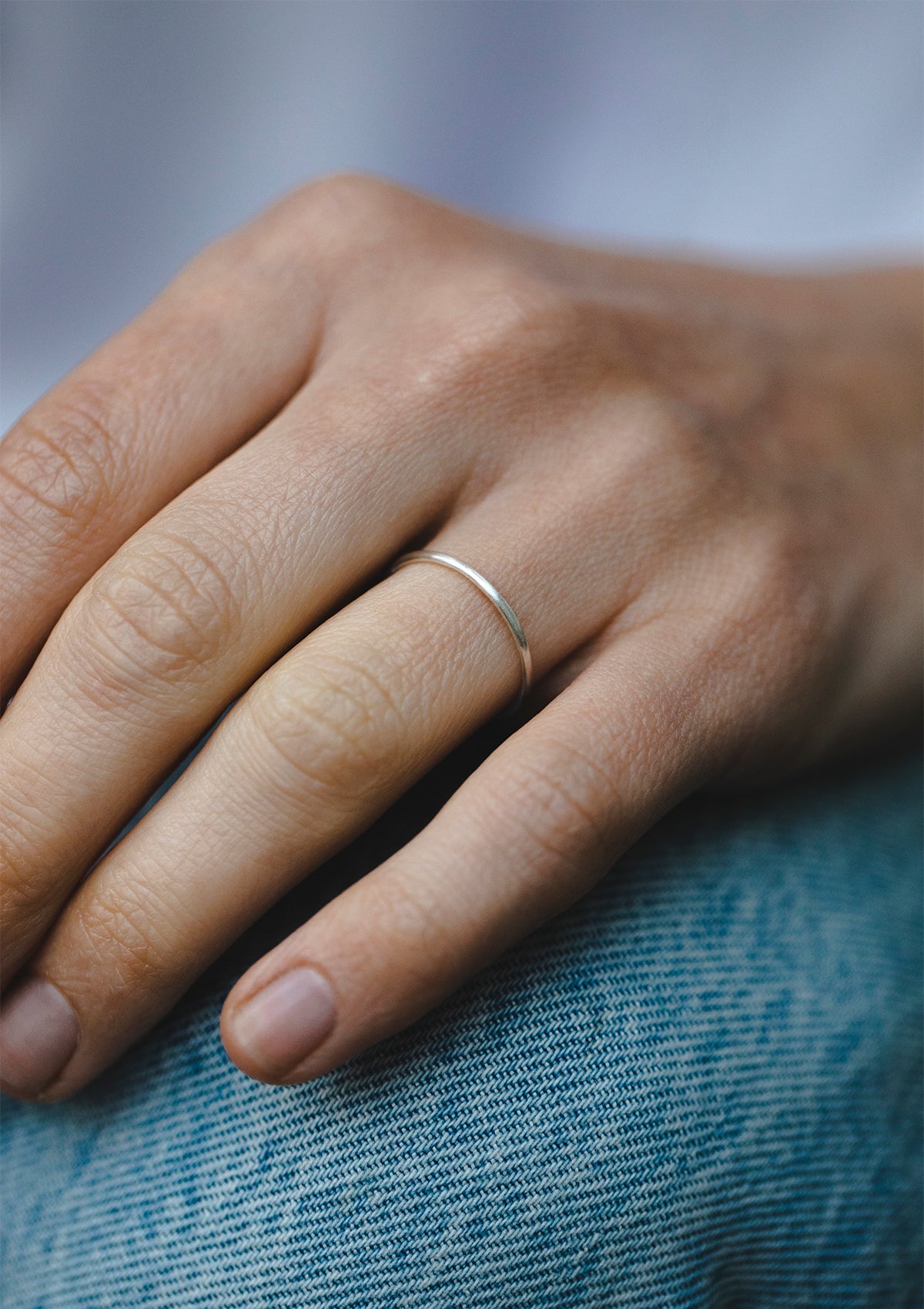 Sterling silver thin stacking ring on hand with shiny finish