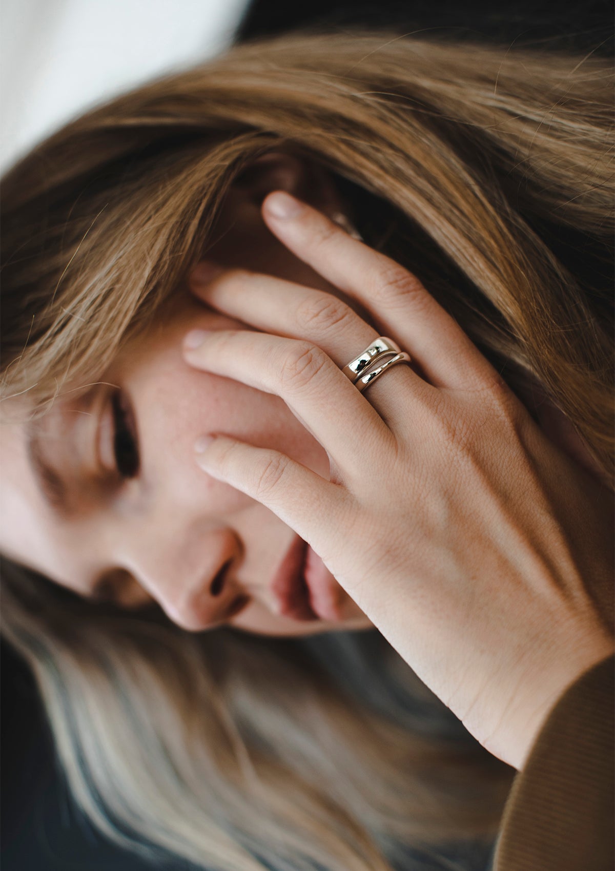 Artistic portrait with silver double ring resting on cheek – contemporary minimalist jewelry for thoughtful gifting