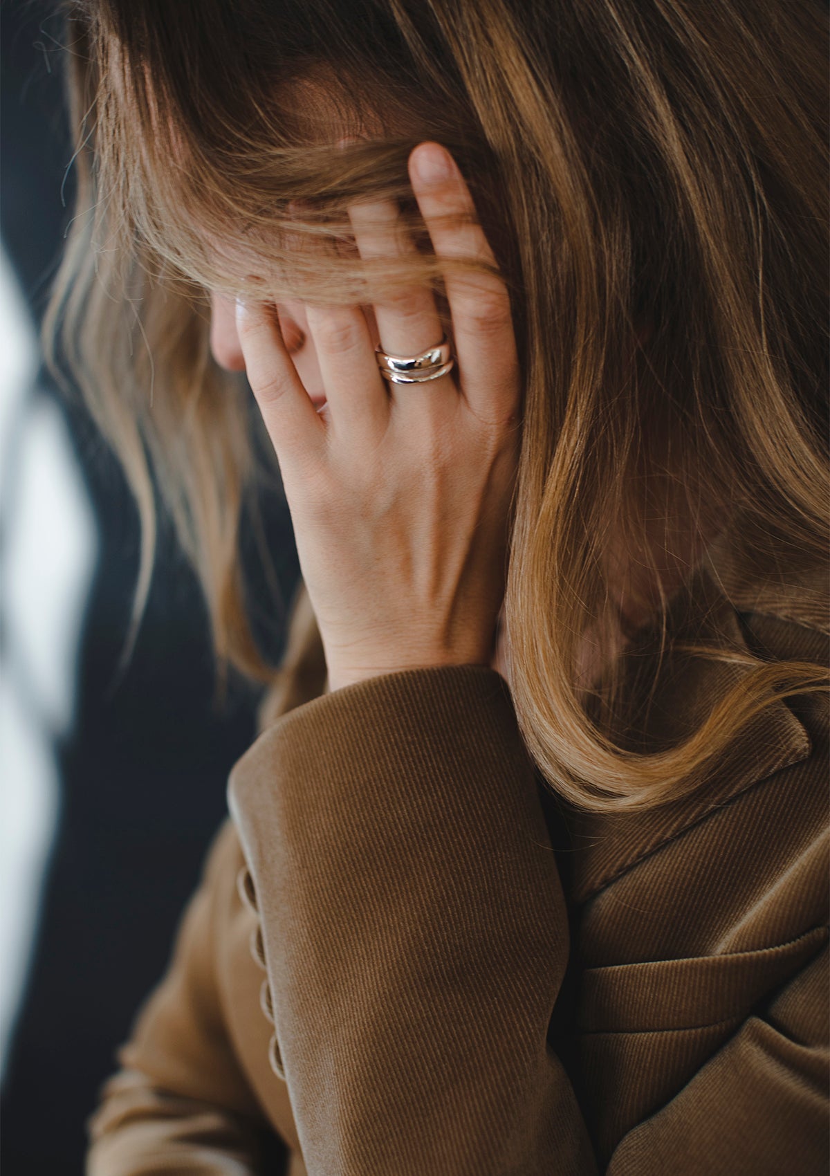 Intimate close-up with hand near face, showcasing shiny silver texture – unique design jewelry made in Berlin
