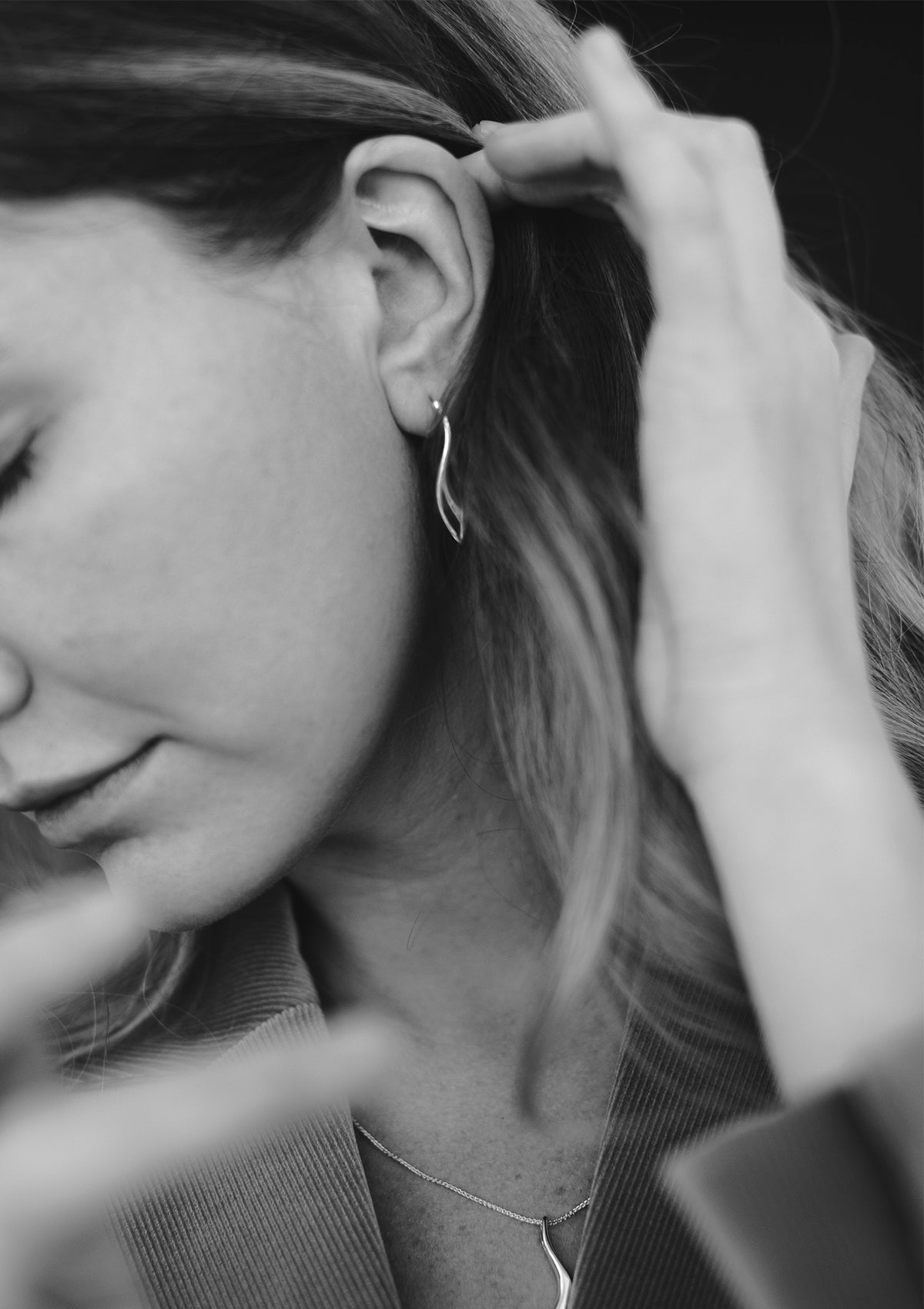 Large statement earrings in sterling silver with polished mirror finish, styled with coat