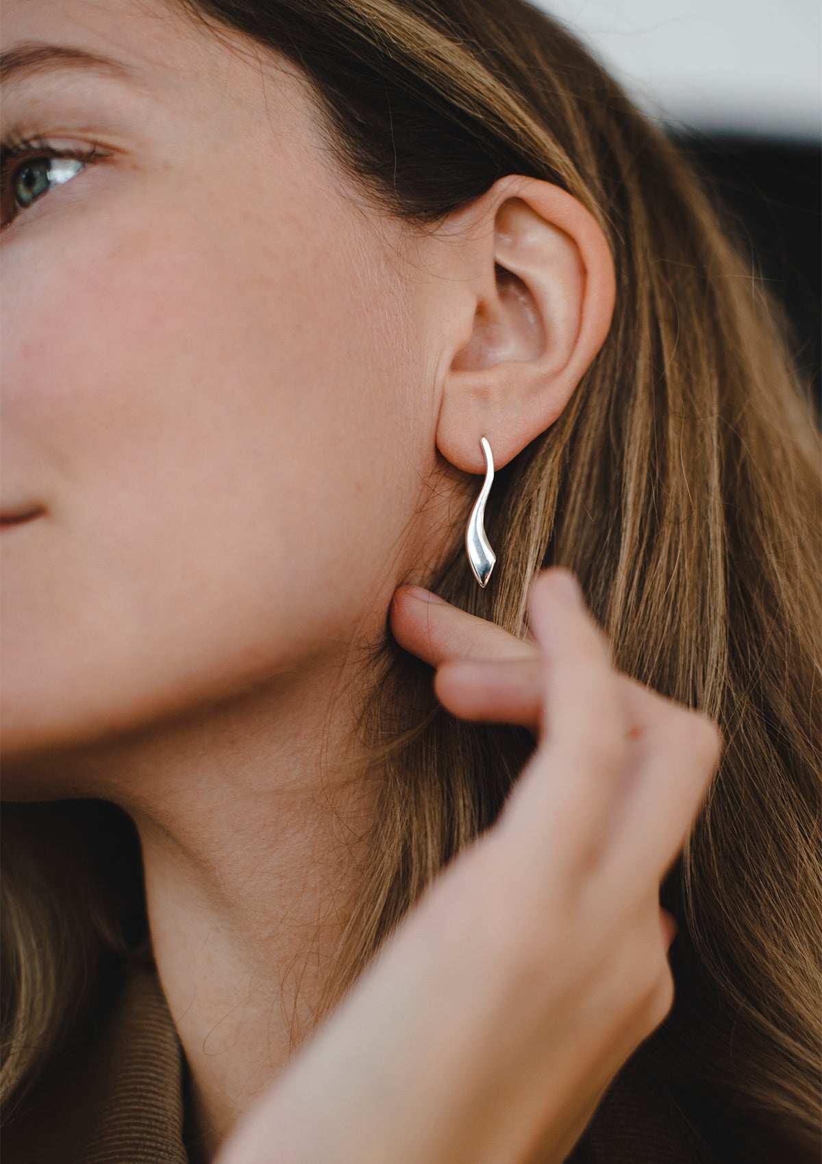 Bold sterling silver earrings with curved silhouette, modern flat shape styled casually