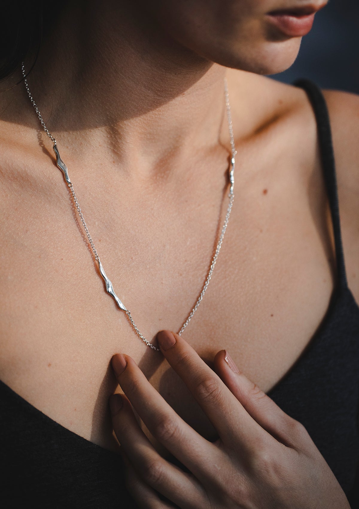 Designer silver necklace with fluid pendant shapes, unique handcrafted jewelry piece