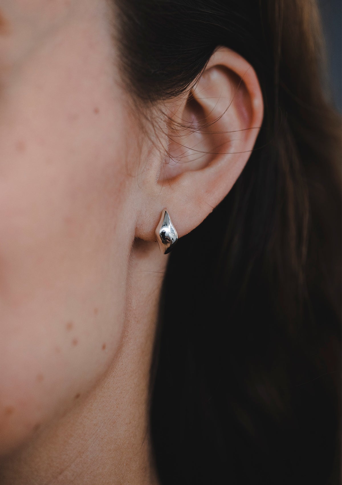 Tiny silver drop huggies for daily wear, minimalist sterling silver earrings shown in ear