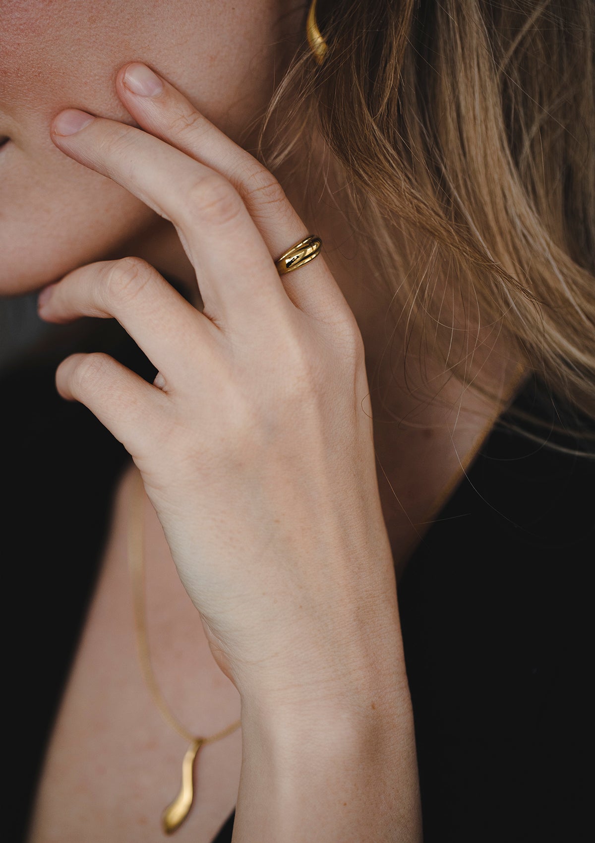 Elegant 14K yellow gold ring styled with black outfit, modern dome silhouette