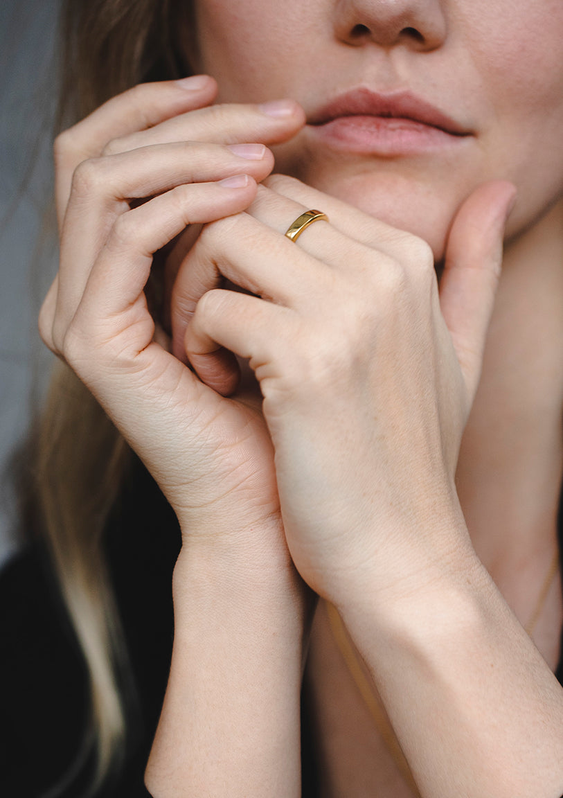 Close-up of gold ring on fingers, modern geometric 14K band