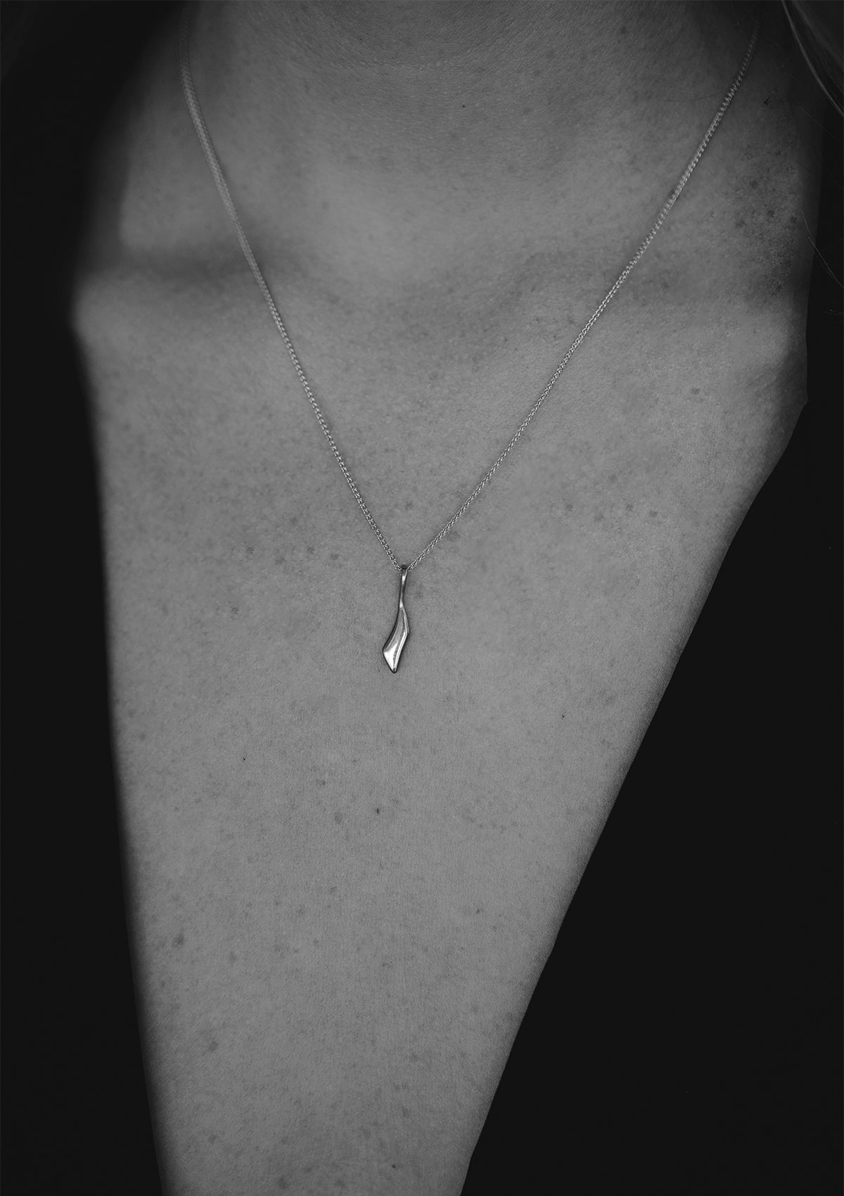 Shiny silver pendant necklace on braided chain, artisanal fine jewelry with timeless appeal