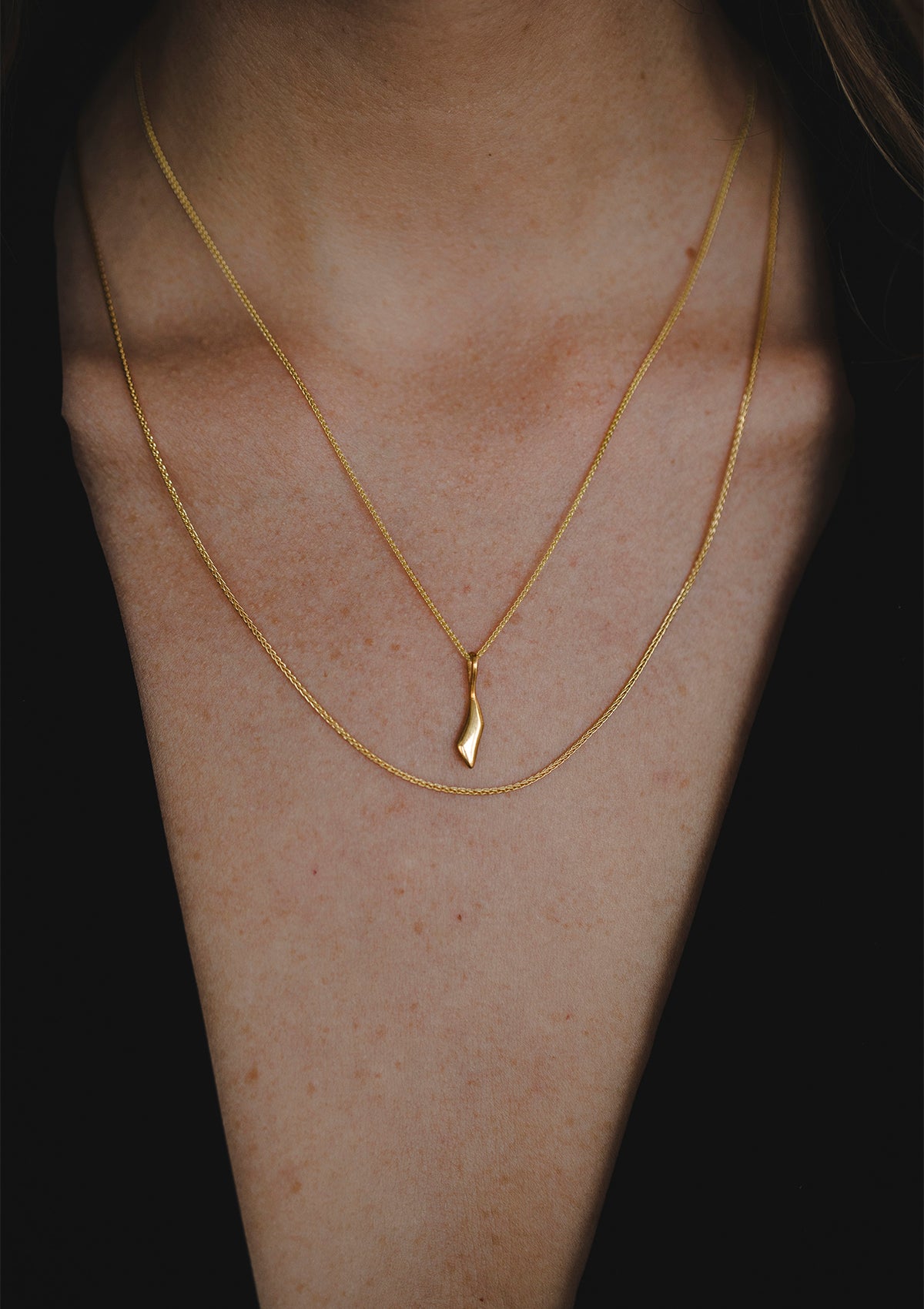 Minimalist 14k gold necklace with signature Sena pendant, layered with fine chain jewelry for refined look