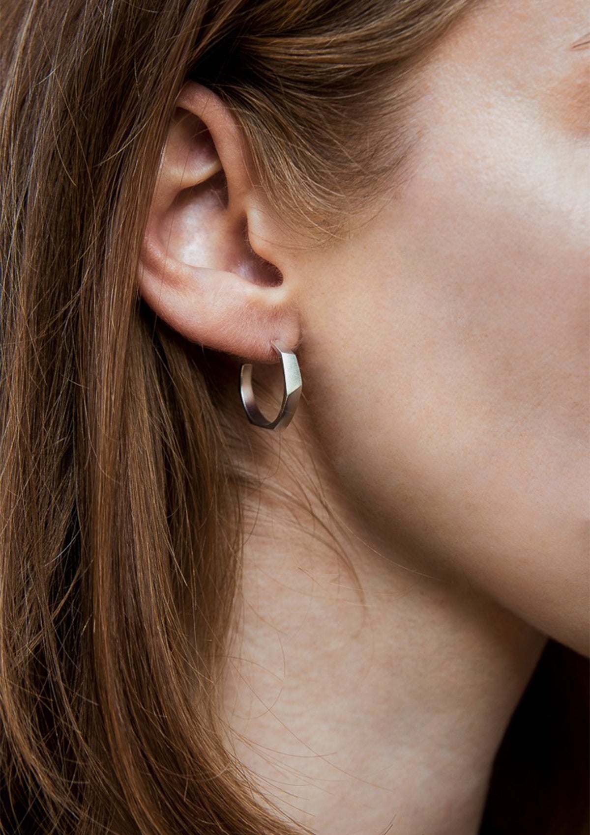 Contemporary silver hoop earrings with angular shape, minimalist everyday jewelry in sterling silver