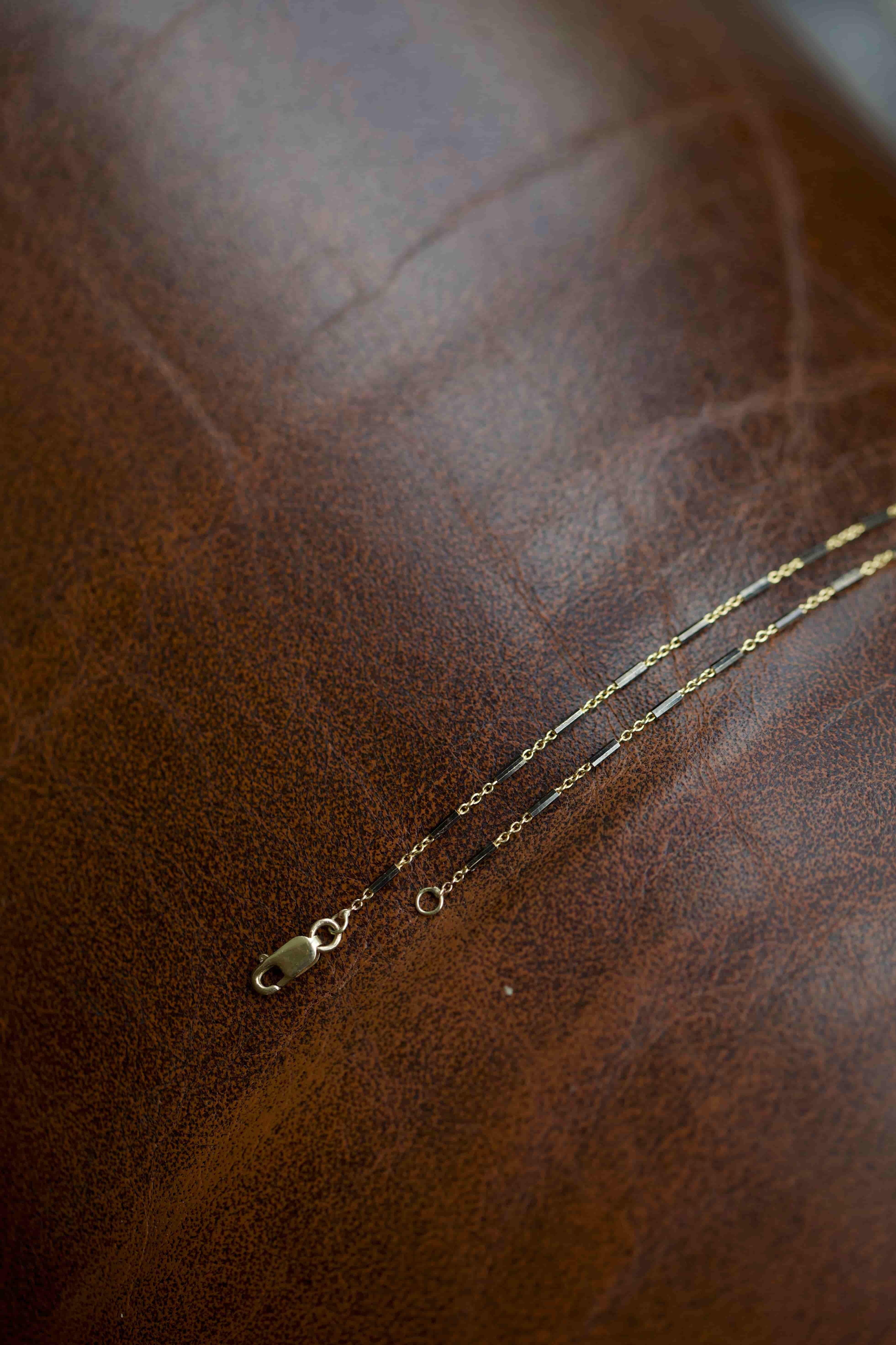 Gold- und schwarze Kettenarmband