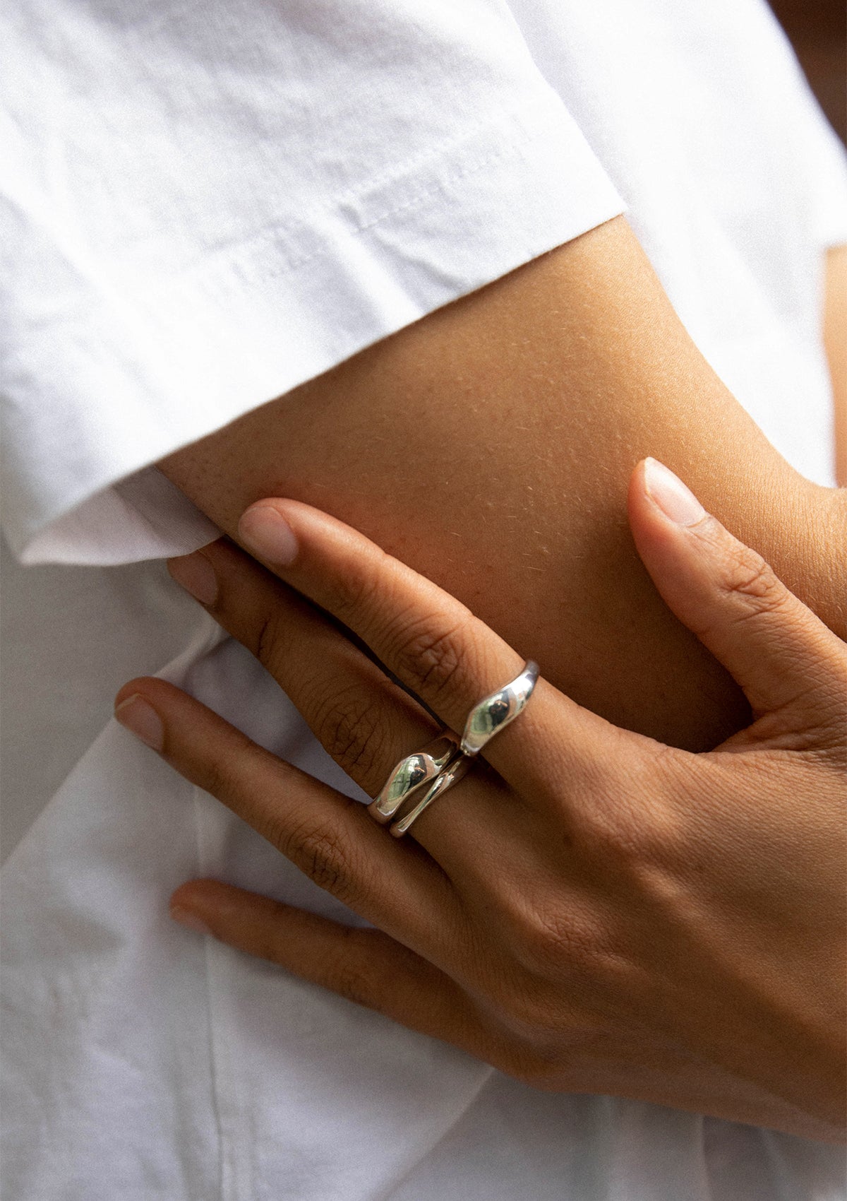Minimalist sterling silver ring with sleek ripple shape, contemporary wave-inspired design
