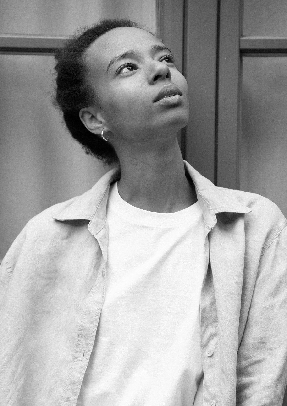 Artistic portrait showing silver sculptural hoops, minimalist modern jewelry in monochrome