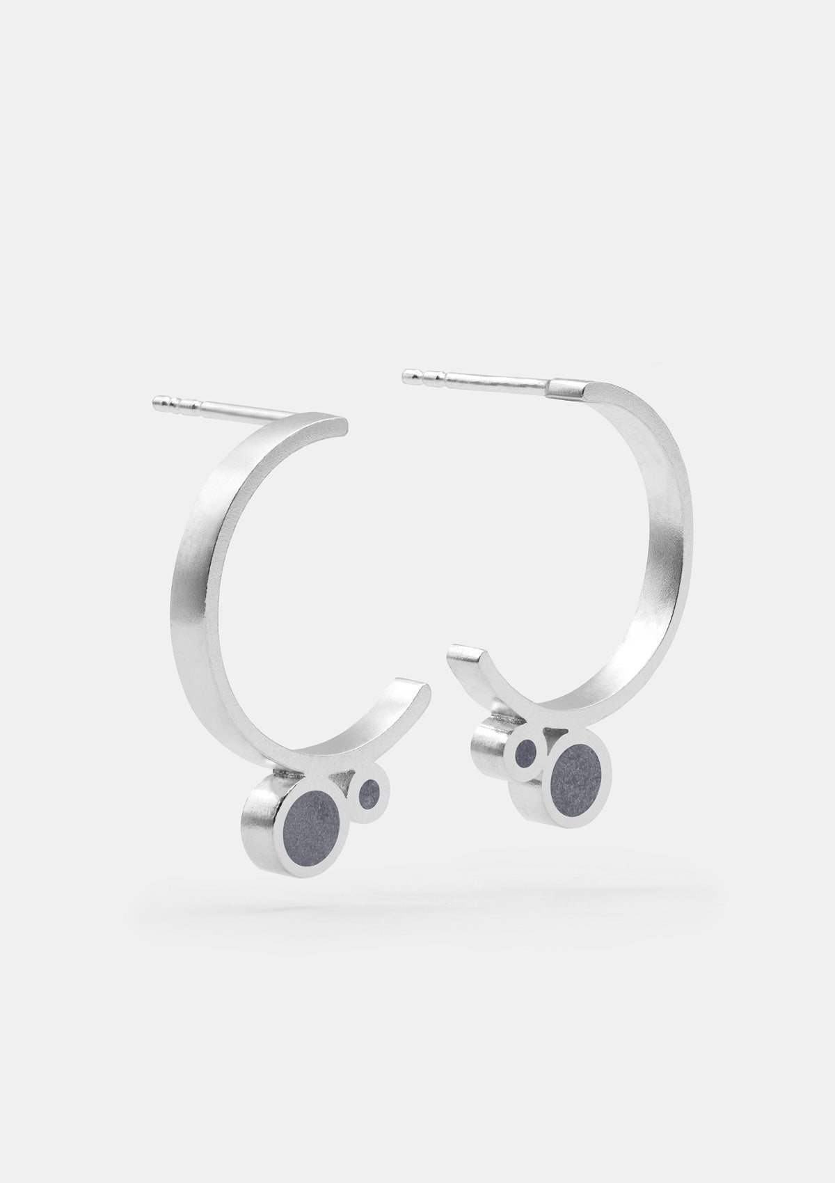 Sterling silver hoop earrings with open circular design, accented by dark gray concrete resin, modern handcrafted look on clean light background