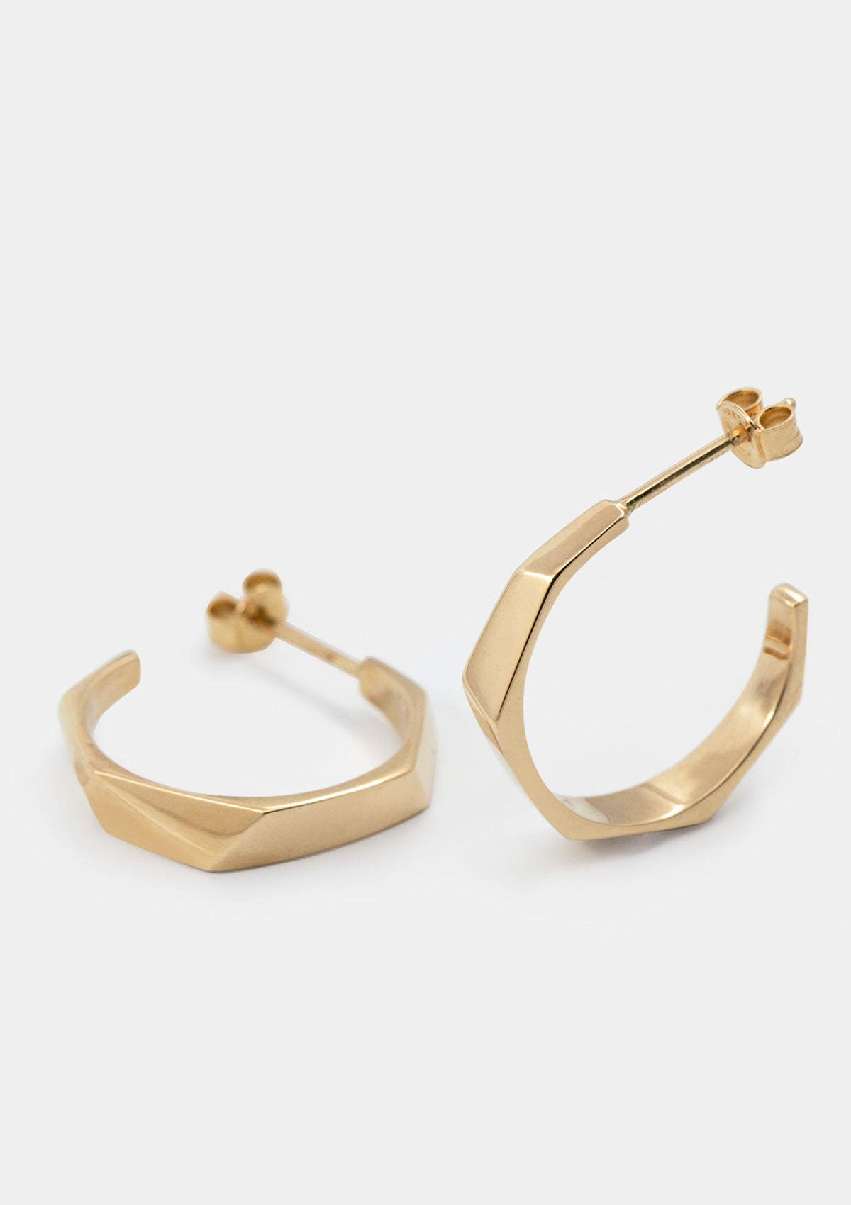 Geometric hoop earrings in 14K solid gold with faceted surface, modern minimalist gold jewelry photographed flat