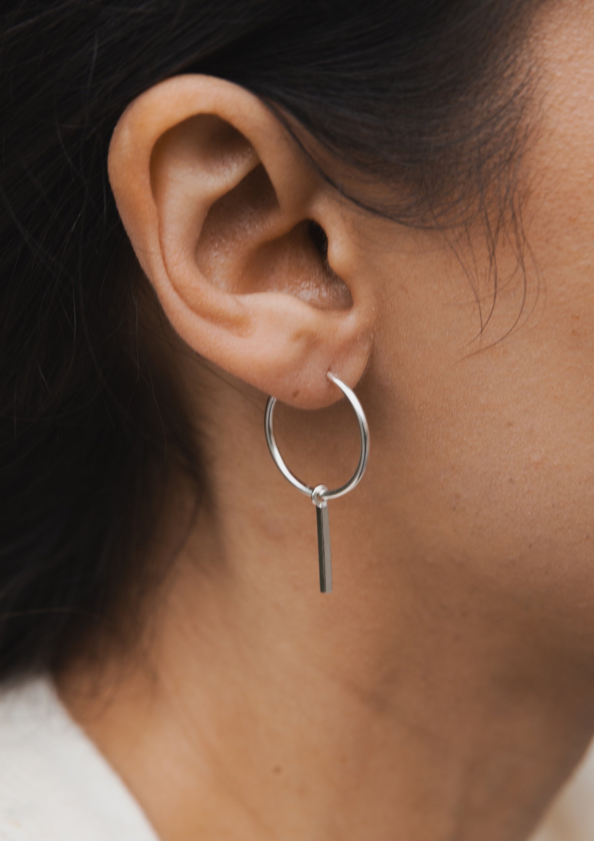 Bar hoop earrings in sterling silver worn on ear