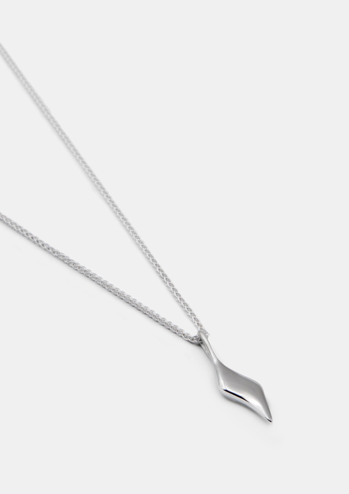 Sterling silver necklace with sculptural pendant, minimalist jewelry photographed flat