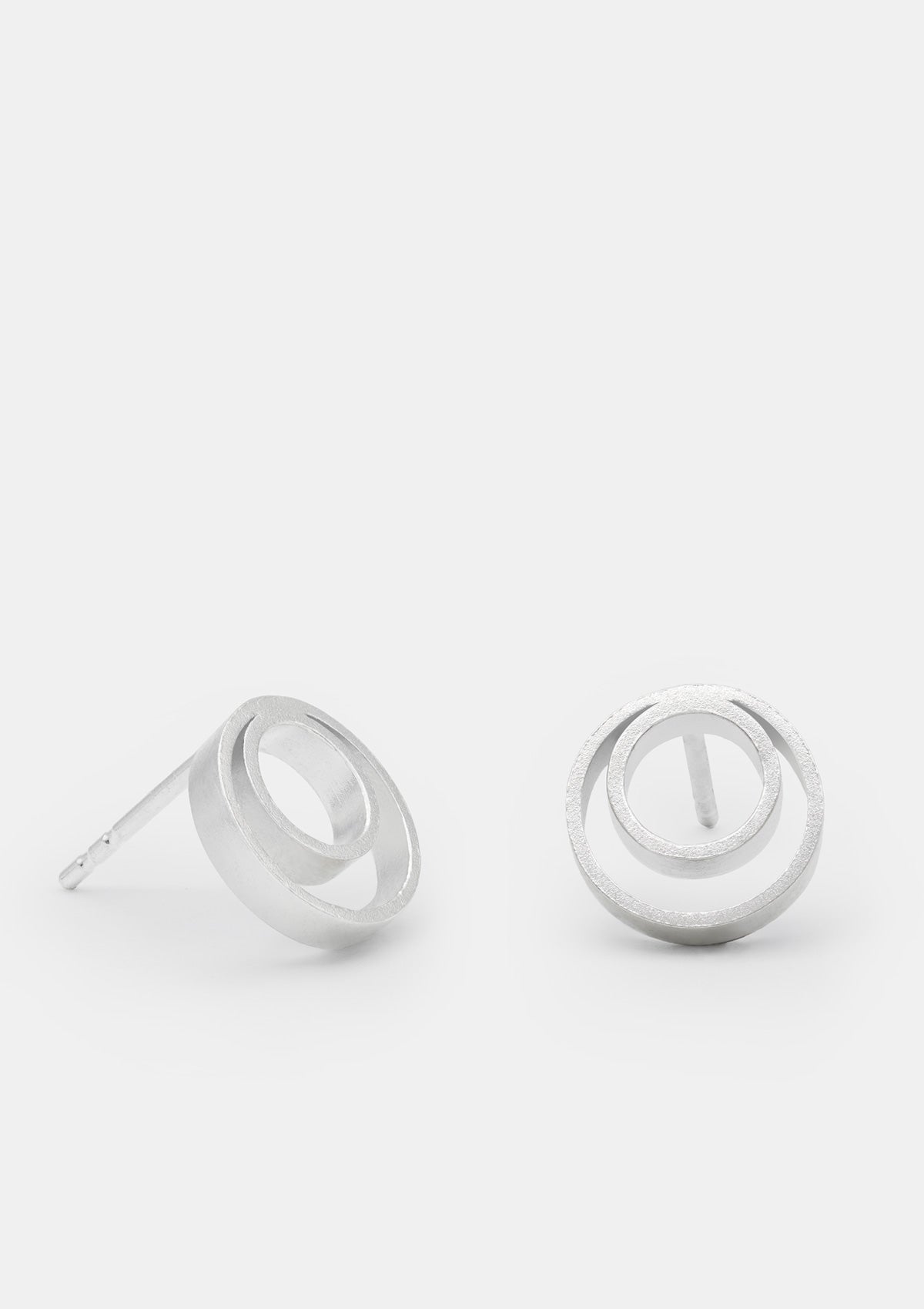 Sterling silver round stud earrings, double-circle geometric design, minimal style, displayed on soft light backdrop