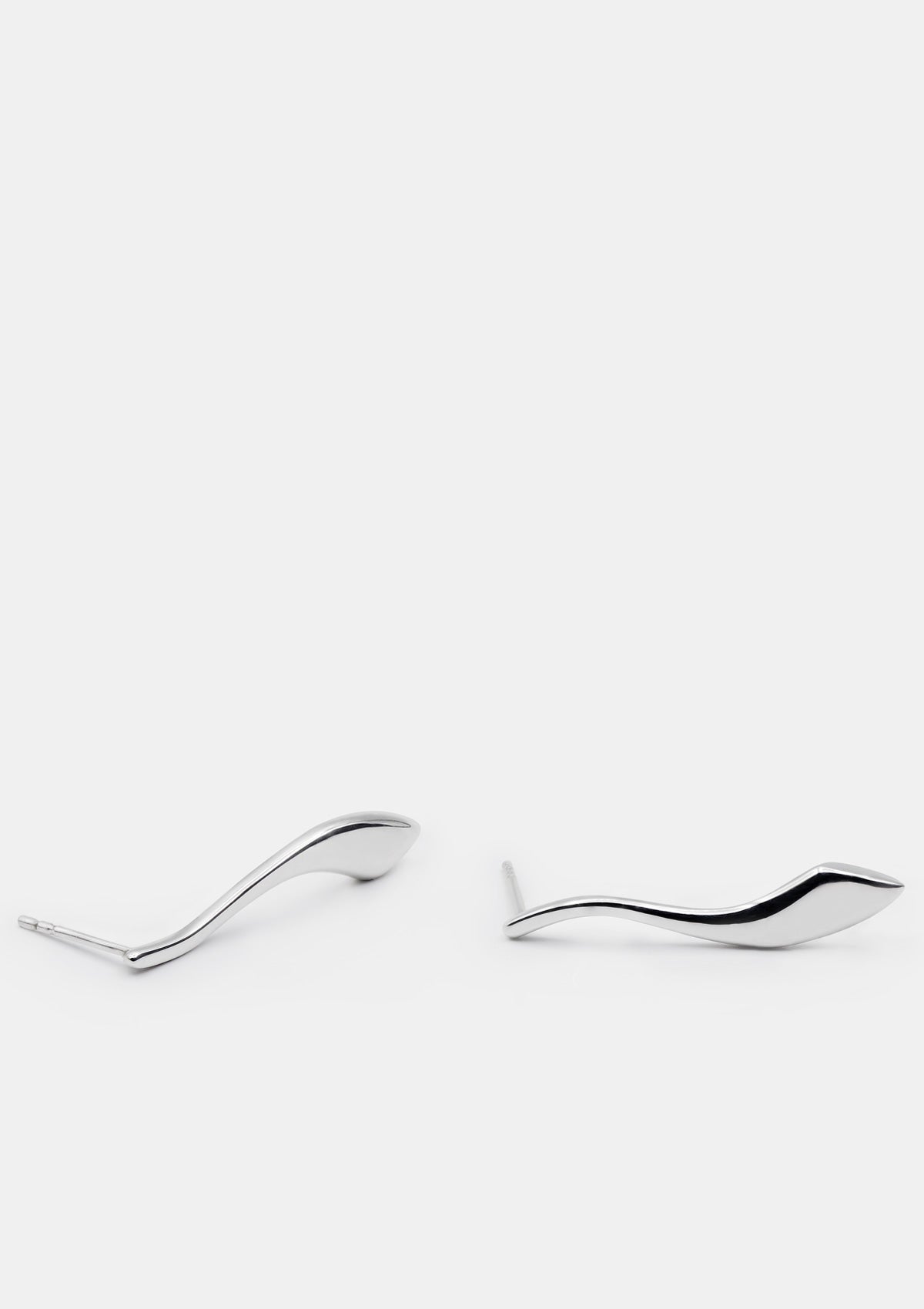 Flat-shaped sterling silver earrings worn close to ear, sculptural and medium in size