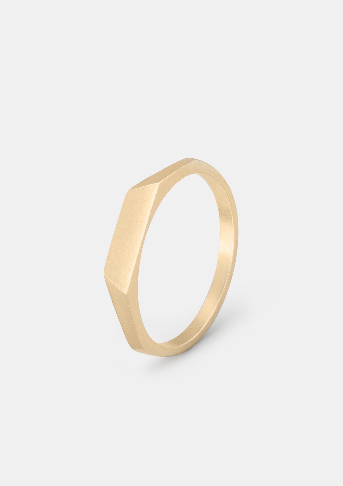 14K gold faceted ring with angled geometric pattern, minimalist wedding band photographed flat