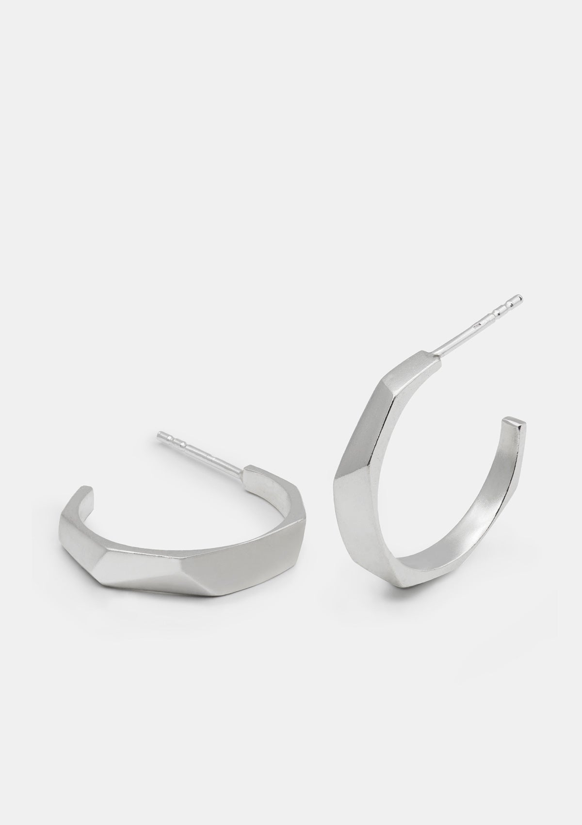 Geometric silver hoop earrings with faceted design, minimalist 925 sterling silver jewelry photographed flat