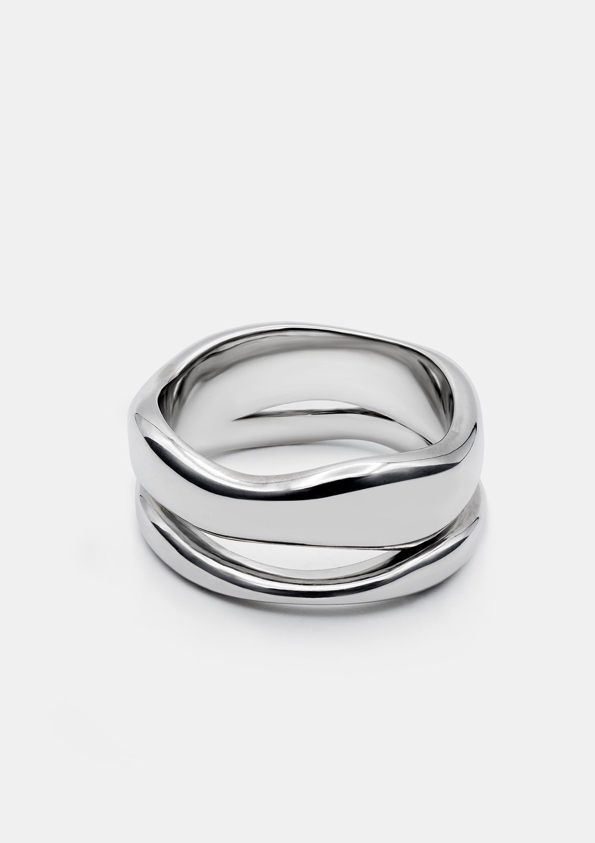 Polished sterling silver double ring with fluid, sculptural silhouette on white background – minimalist statement jewelry