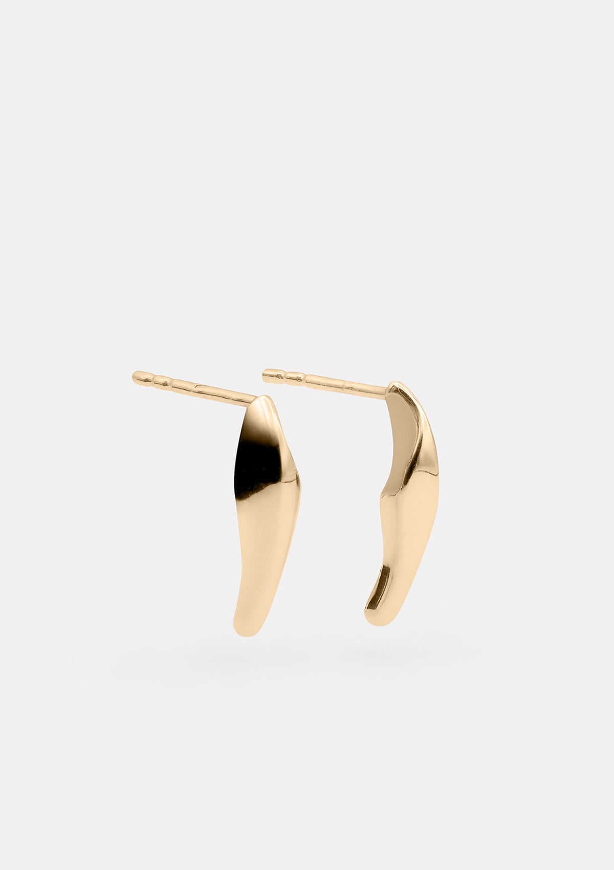 Designer gold earrings arranged diagonally, sculptural miniature earrings with refined artisan look