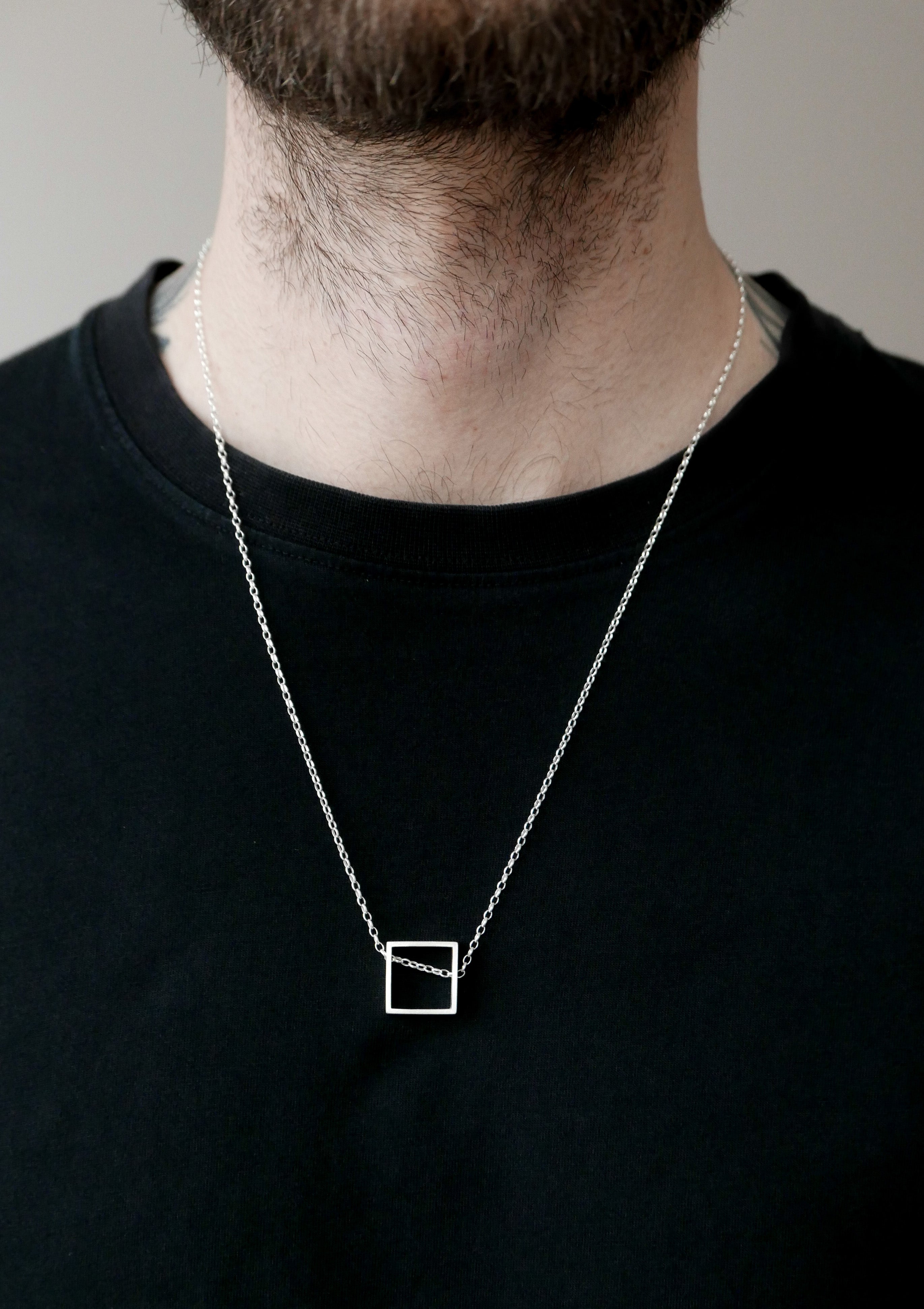 Asymmetrical mens square necklace in sterling silver, elegant matte pendant positioned diagonally in natural posture