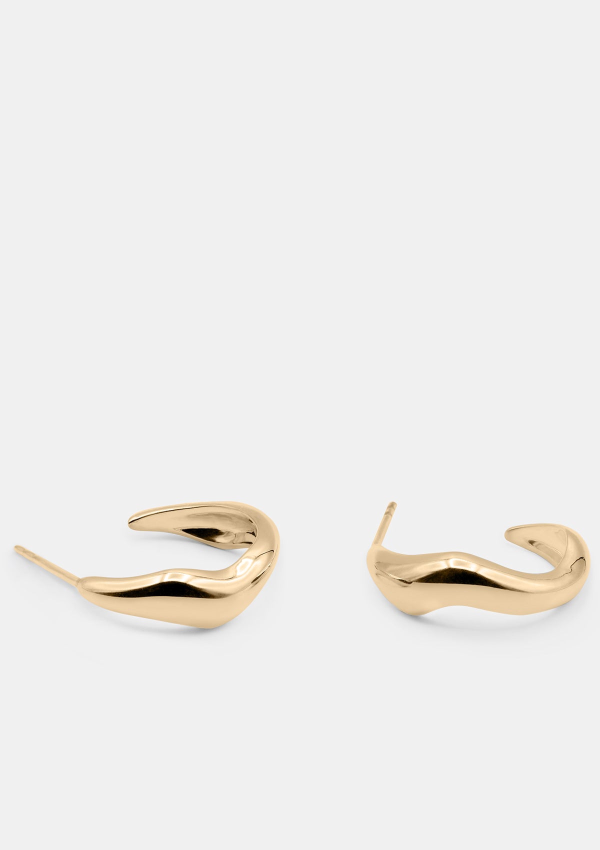 14K gold hoop earrings with sculptural curved form, modern lightweight design photographed flat