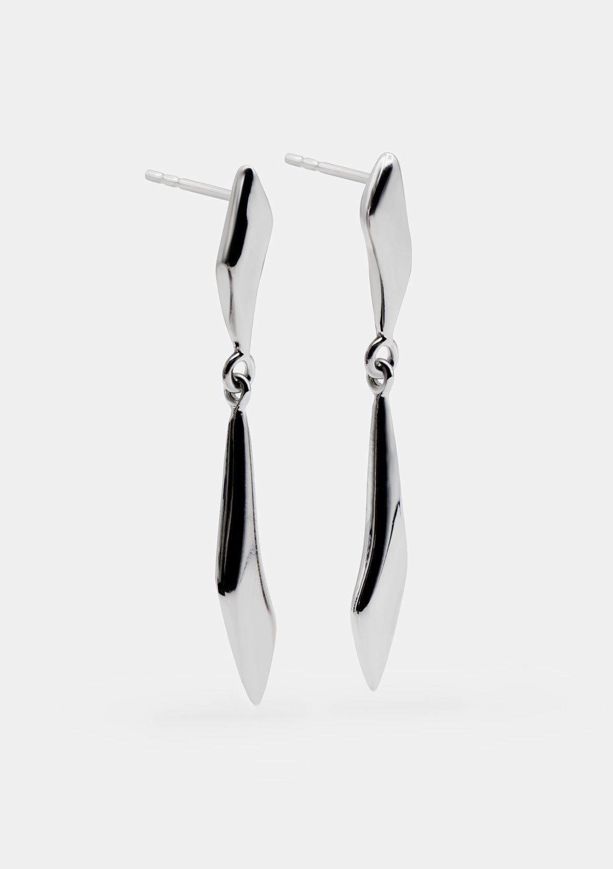 Long sterling silver dangle earrings with polished sculptural pendants, sleek minimalist design