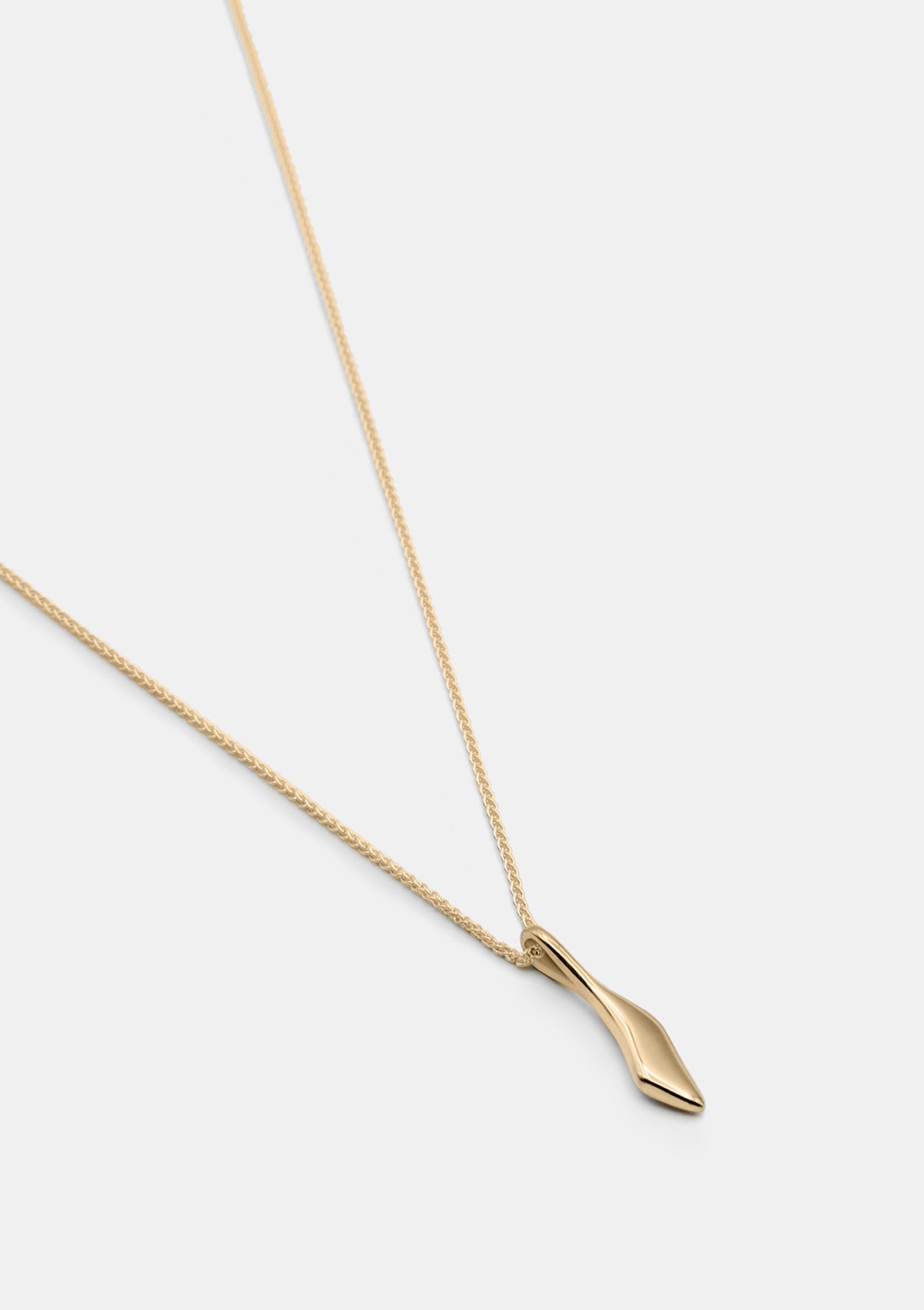 Tiny sculptural gold pendant necklace with braided Spiga chain, classic fine jewelry photographed flat