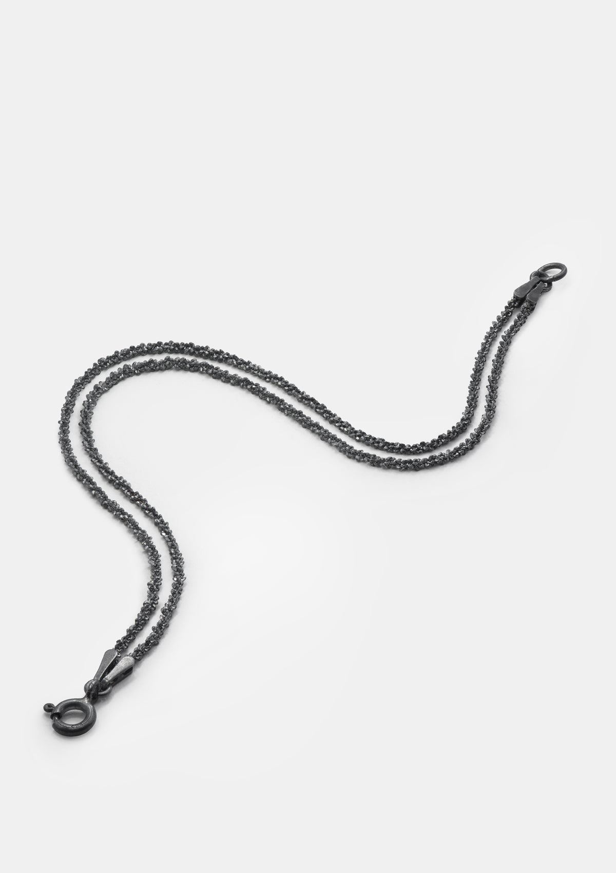Curled oxidized sterling silver bracelet with double chains – studio image