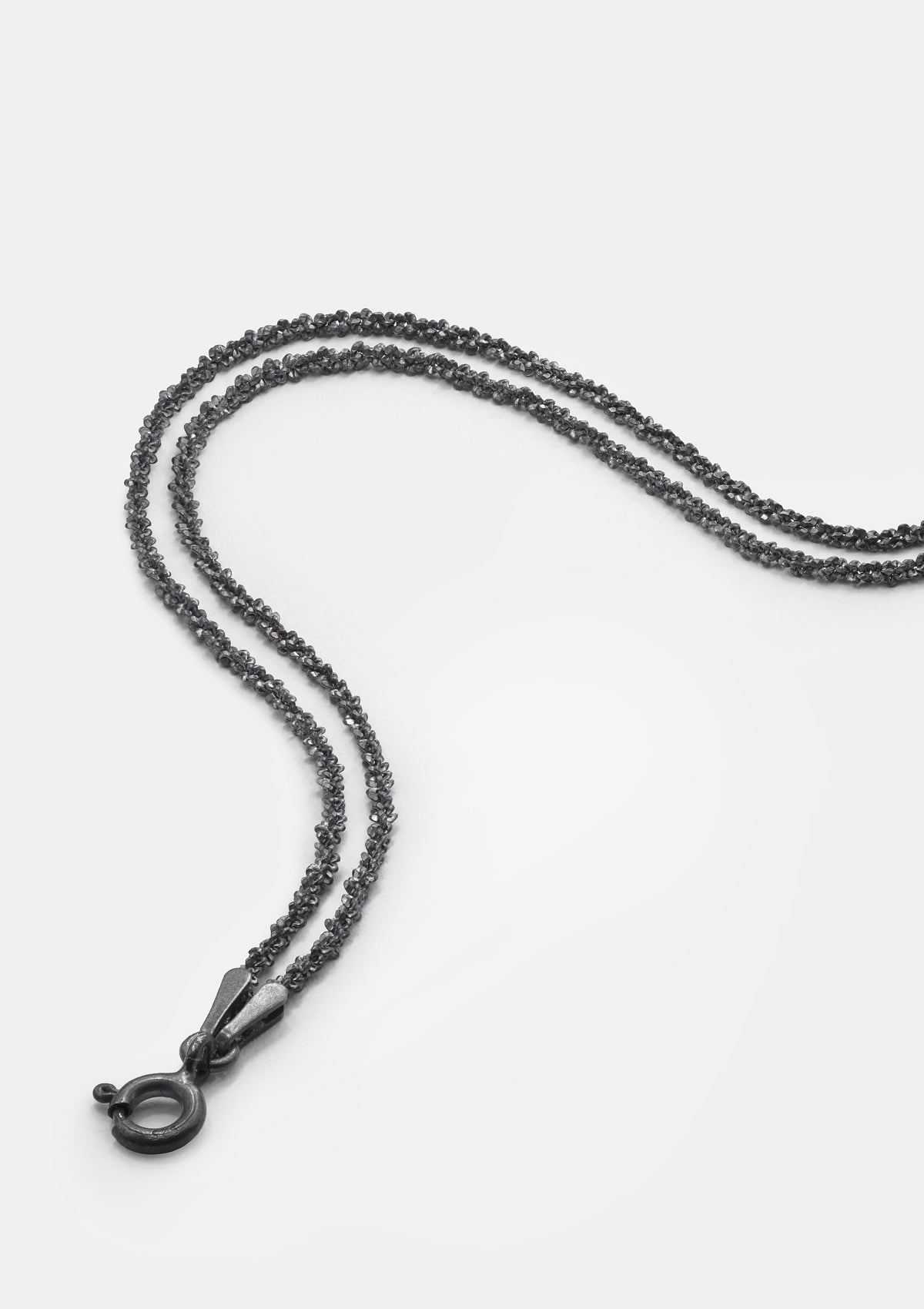 Oxidized sterling silver double chain bracelet laid flat on light gray background – minimalist design