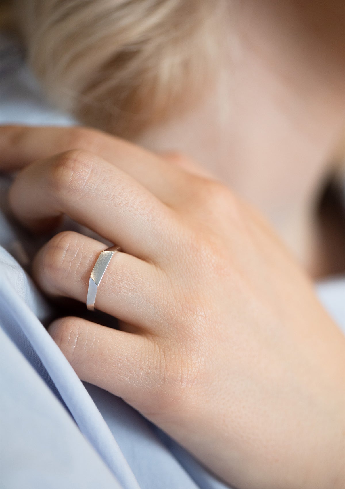 Sterling silver ring with light-catching facets, subtle artisan piece worn near hairline