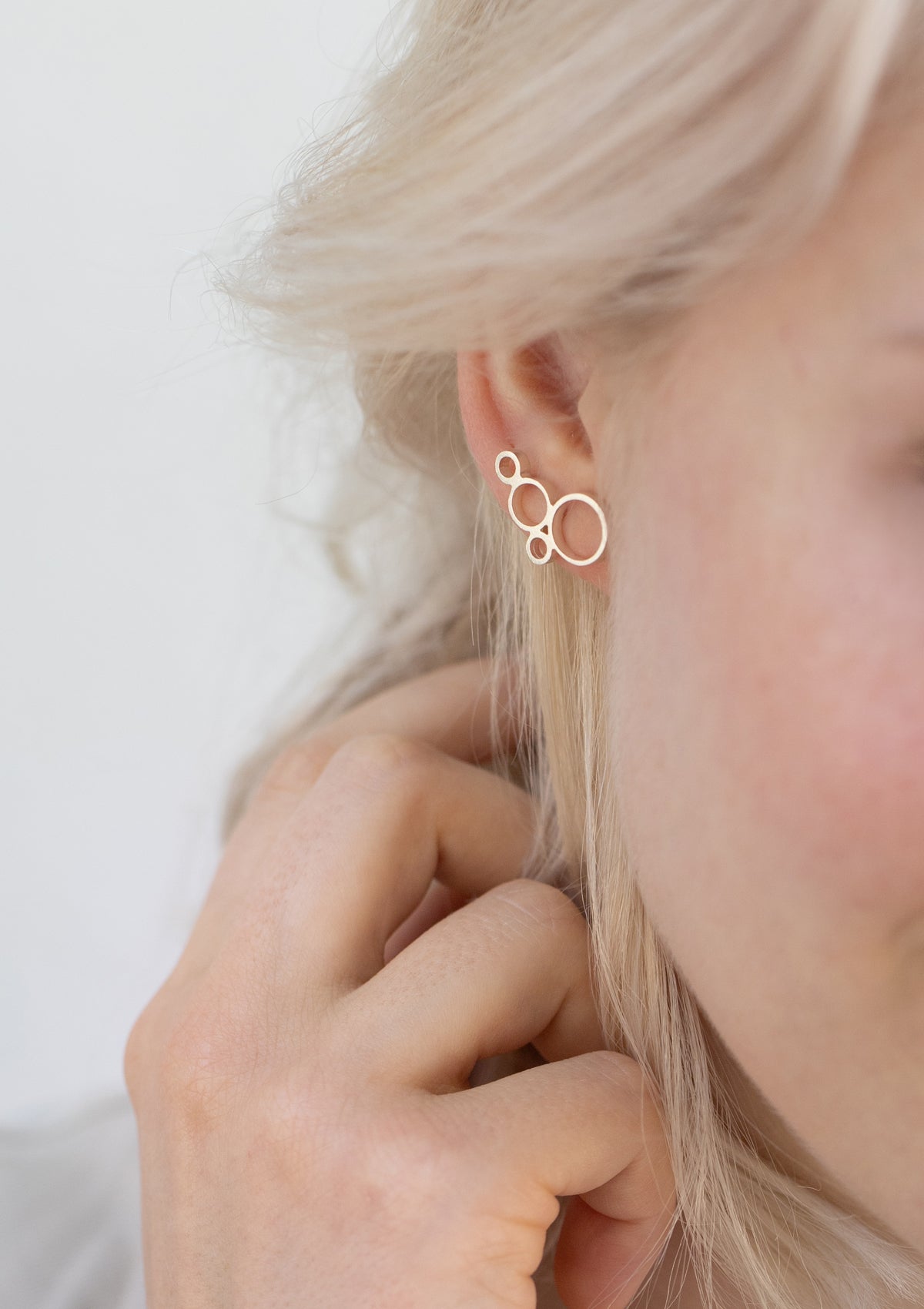 Silver geometric stud earrings worn on ear, modern design climbing earring style, minimalist handmade jewelry