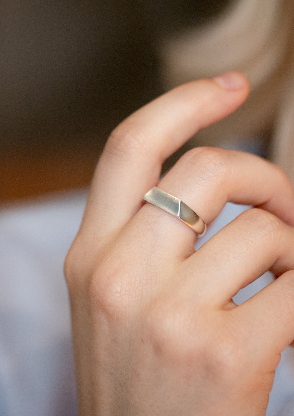 925 silver facet ring worn on hand, angled surface catching soft natural light, contemporary silver jewelry