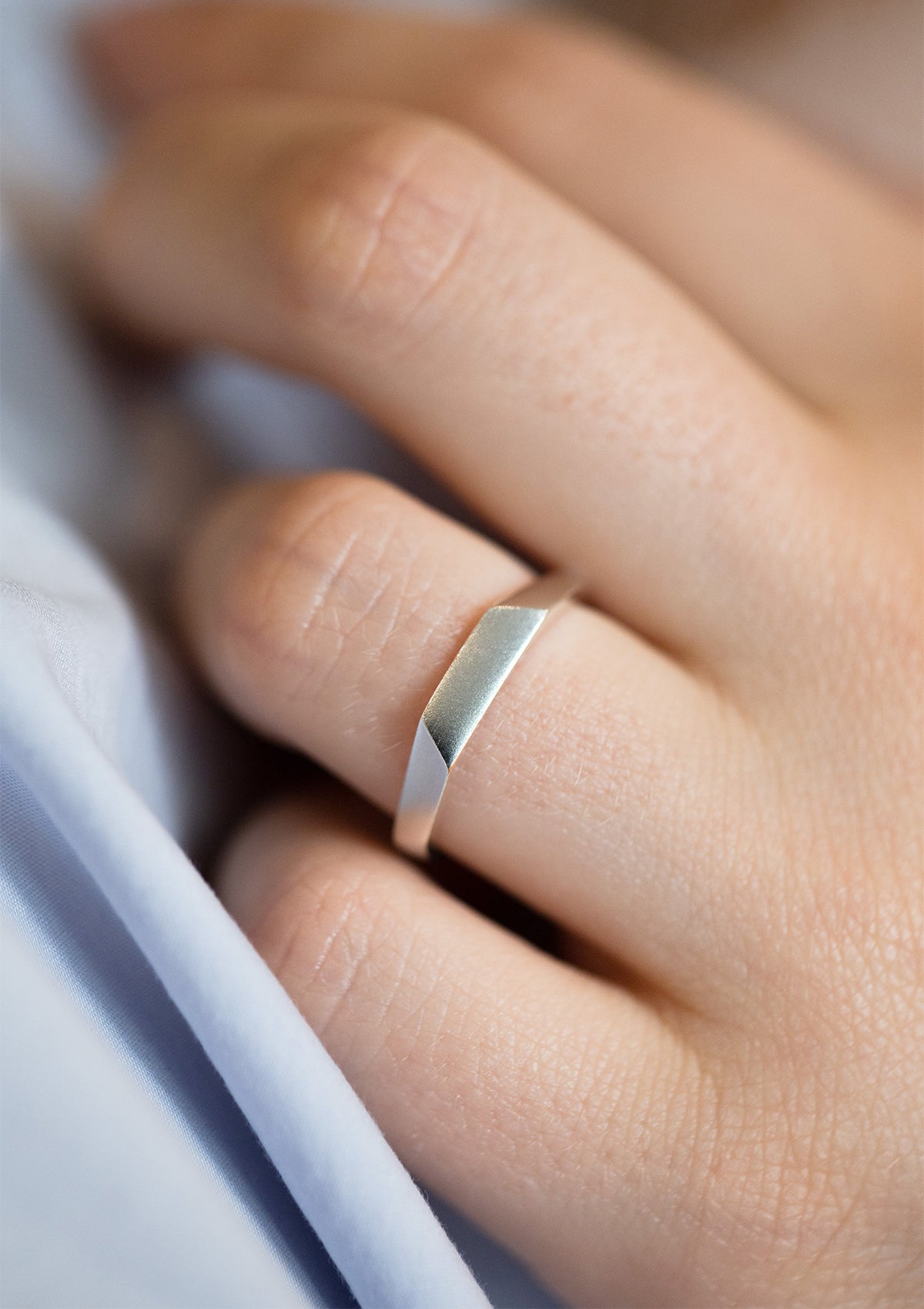 Modern sterling silver stacking ring with geometric facets, worn on finger