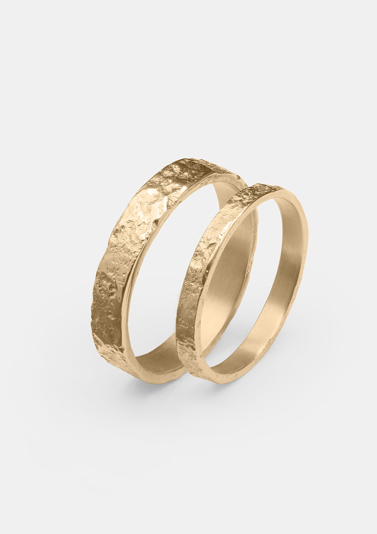 Pair of wedding bands in solid 14K gold with organic hammered texture, handcrafted matte rings photographed flat