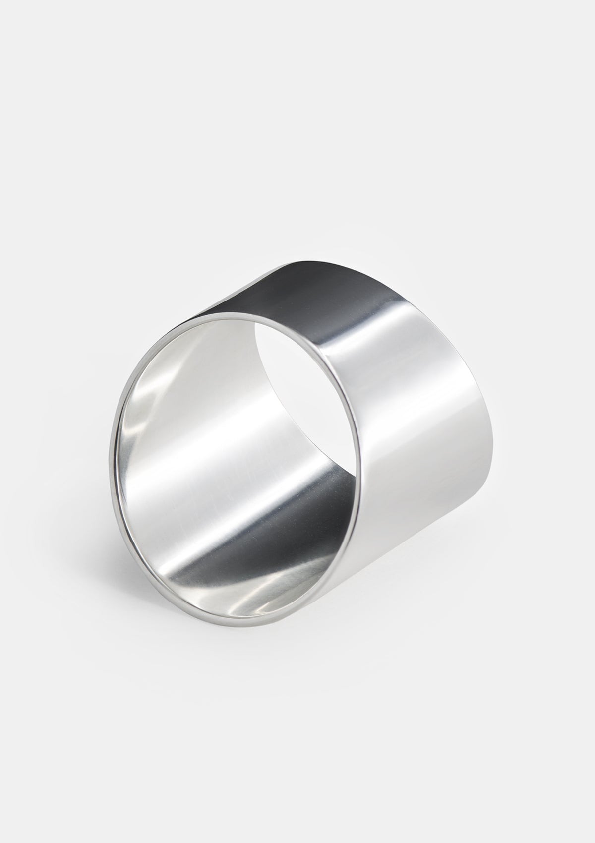 Sterling silver tube ring photographed flat on white, wide sculptural design with polished semi-matte finish