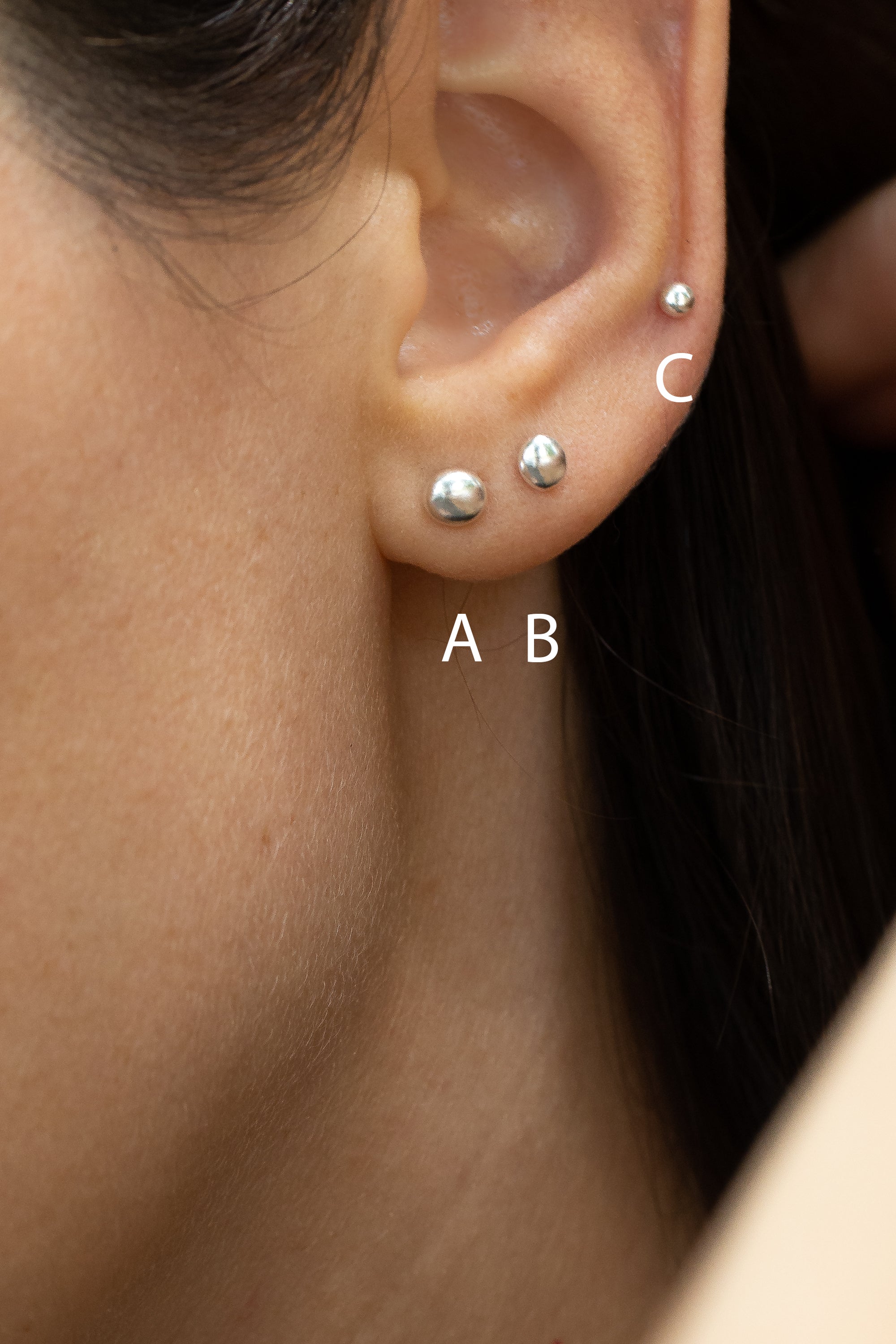 Elegant 925 silver stud earrings with natural pebble texture, delicate design glinting subtly in profile