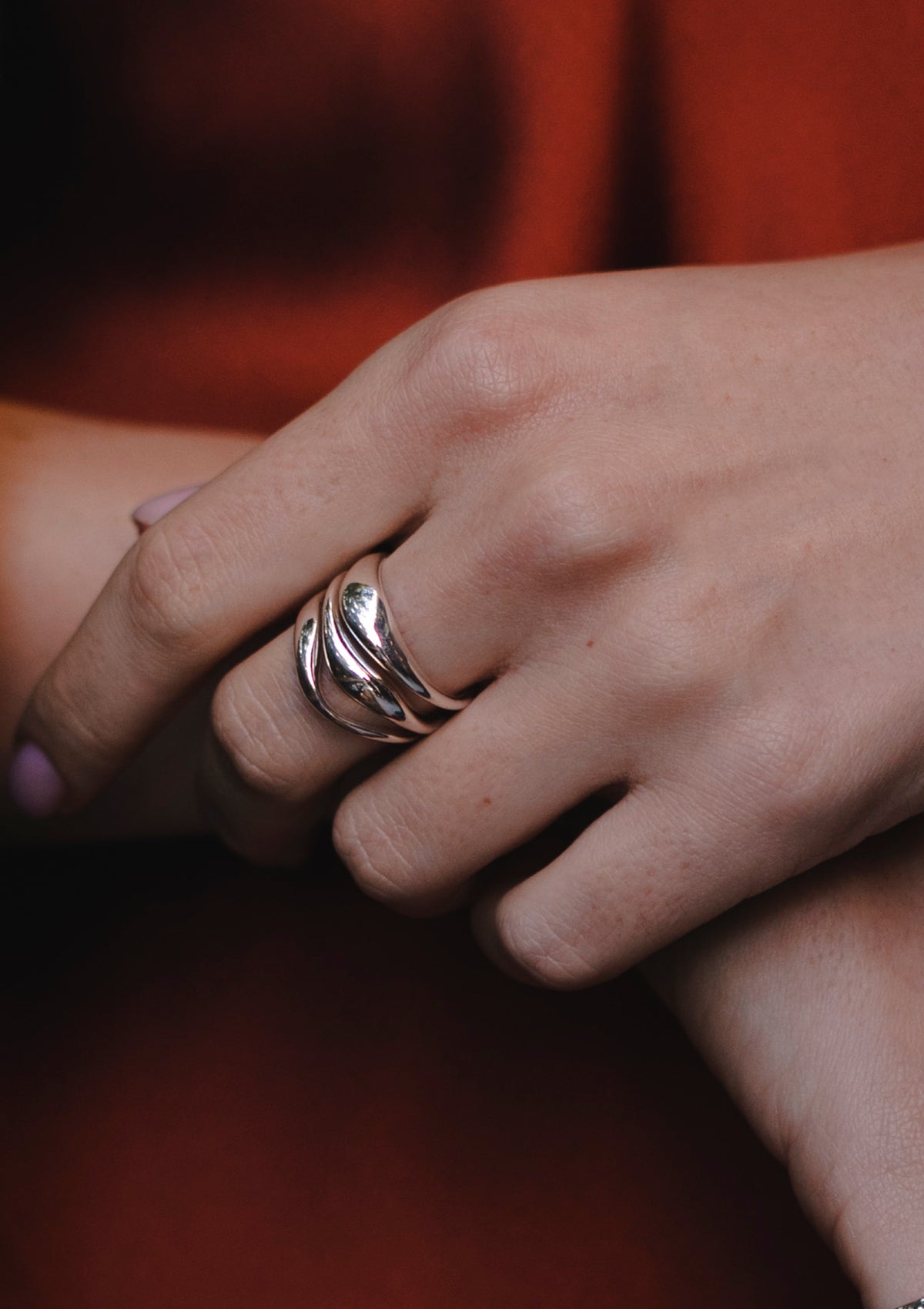 Reflective silver ring catching natural light, artistic jewelry detail